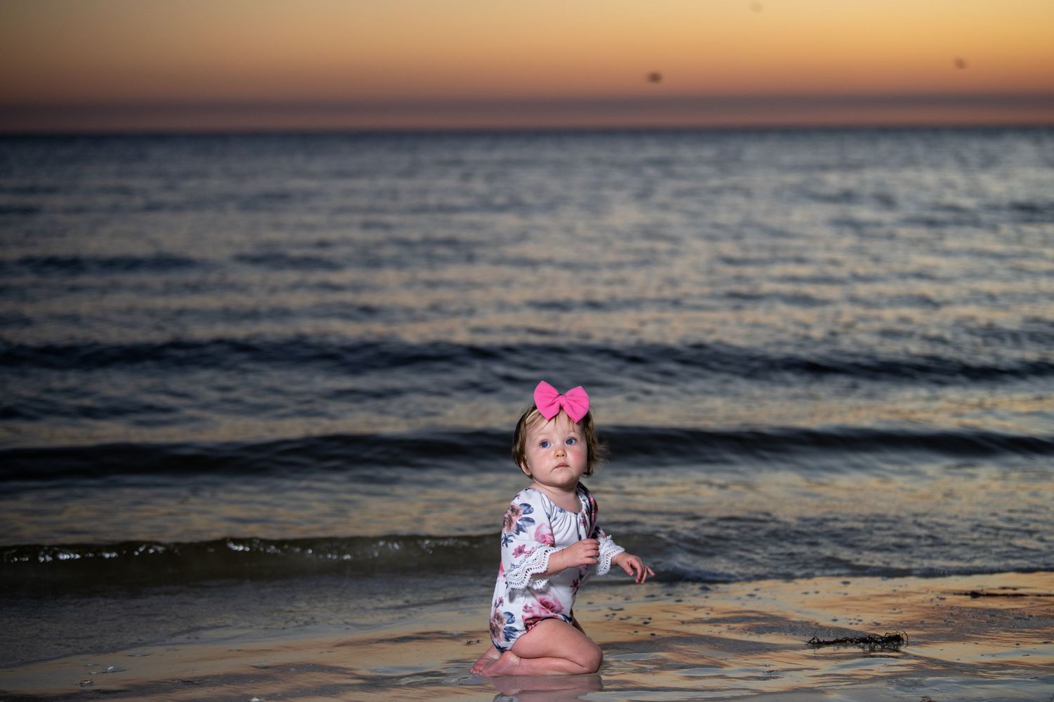 Peaceful beach scene at sunset with gentle waves.