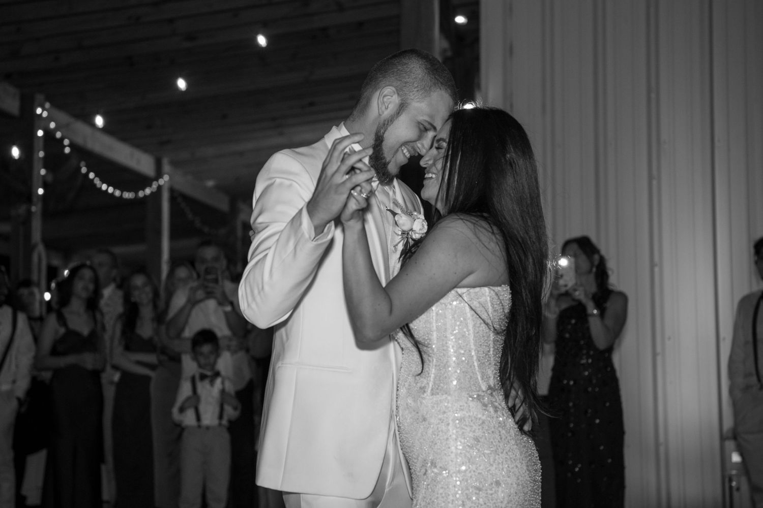 Elegant indoor wedding reception with white decor and string lights creating a romantic atmosphere. Wedding photography.