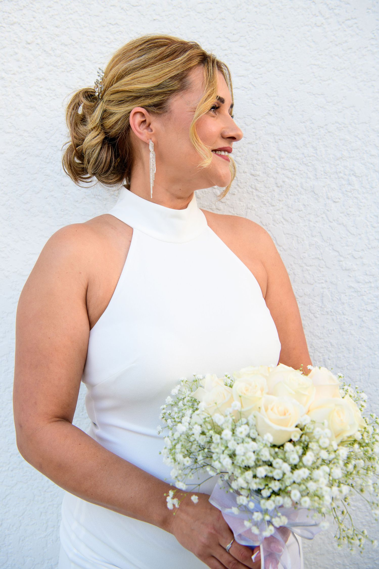 wedding portraits of bride in white halter dress holding wedding bouquet.