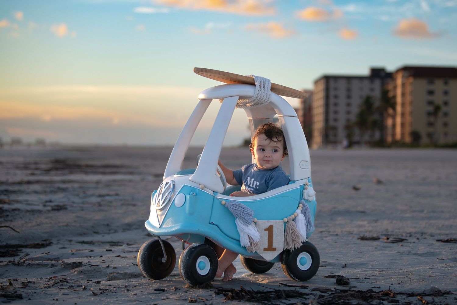 Multiple views of a blue and white toy vehicle on a beach during golden hour.