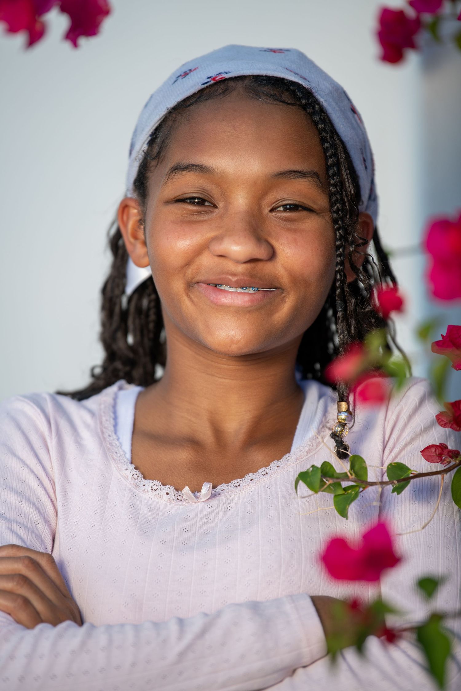 Close-up portrait with bright pink bougainvillea flowers in the background. Headshots.