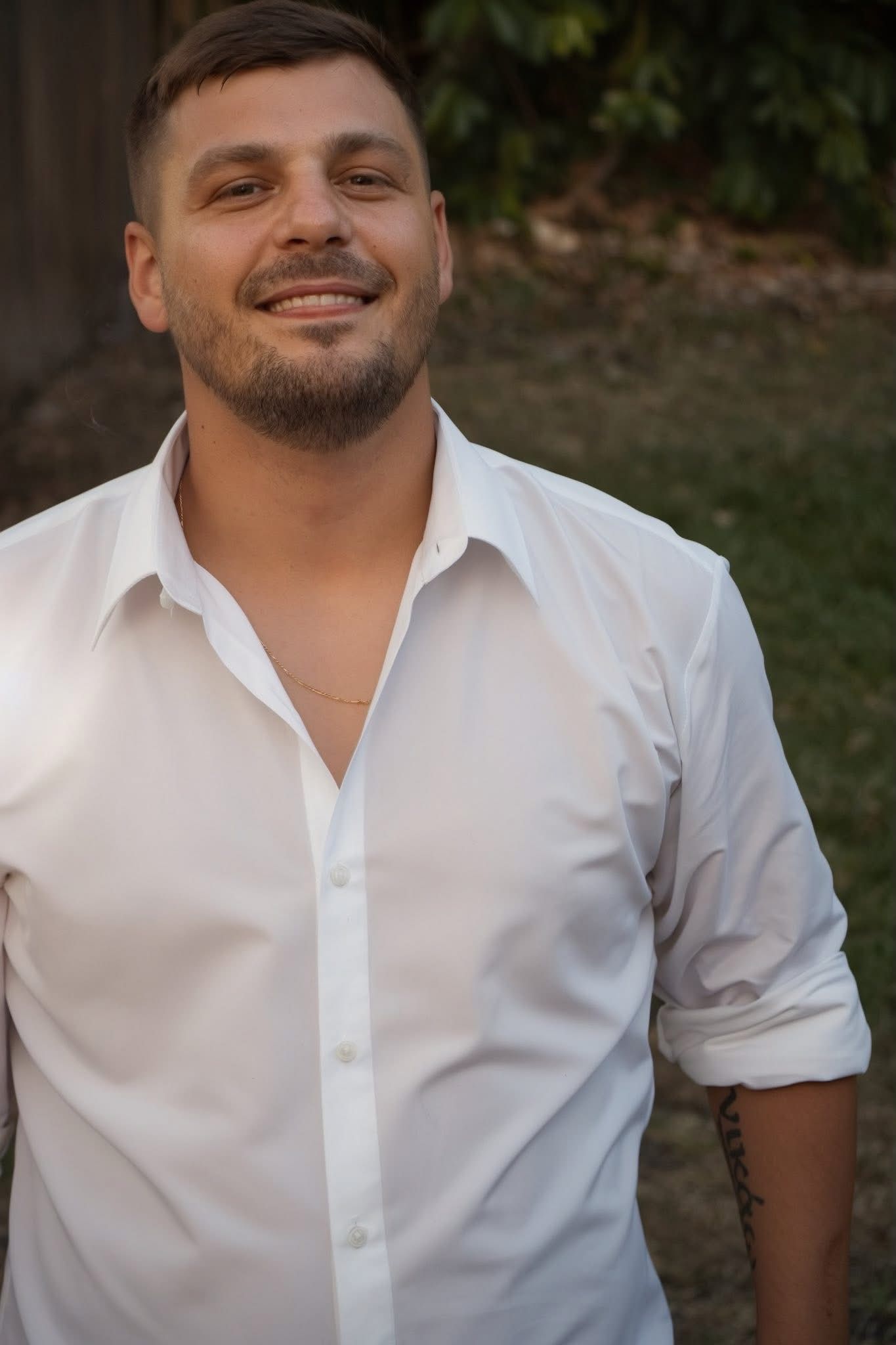 Portrait series showing expressions while wearing a white button-down shirt.