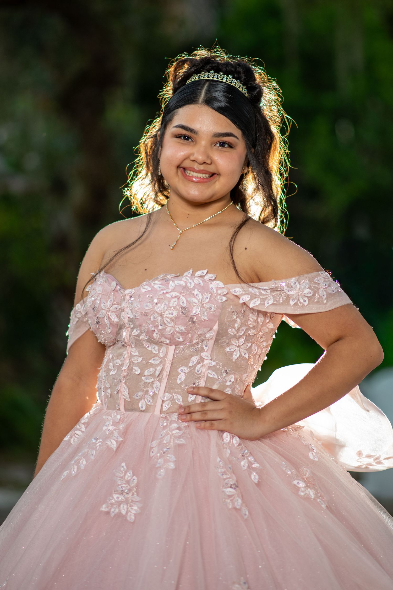 Detailed shots of a pink tulle quinceañera dress with floral appliques in garden setting. Quinceañera photos.