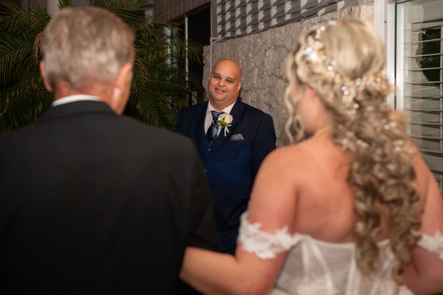 A wedding couple shares an intimate moment in an outdoor evening setting.