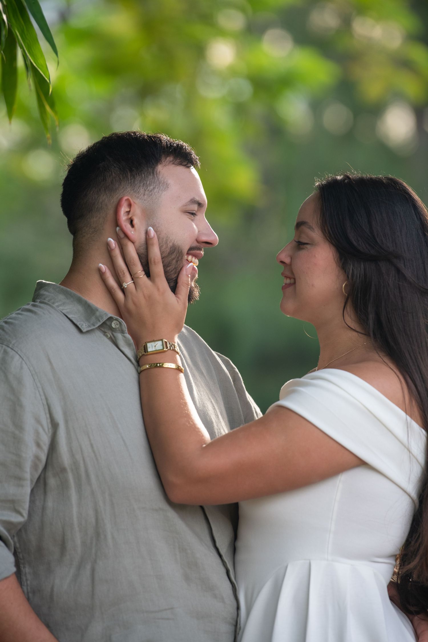 A couple shares laughter and intimate moments in a garden setting with soft natural lighting.
