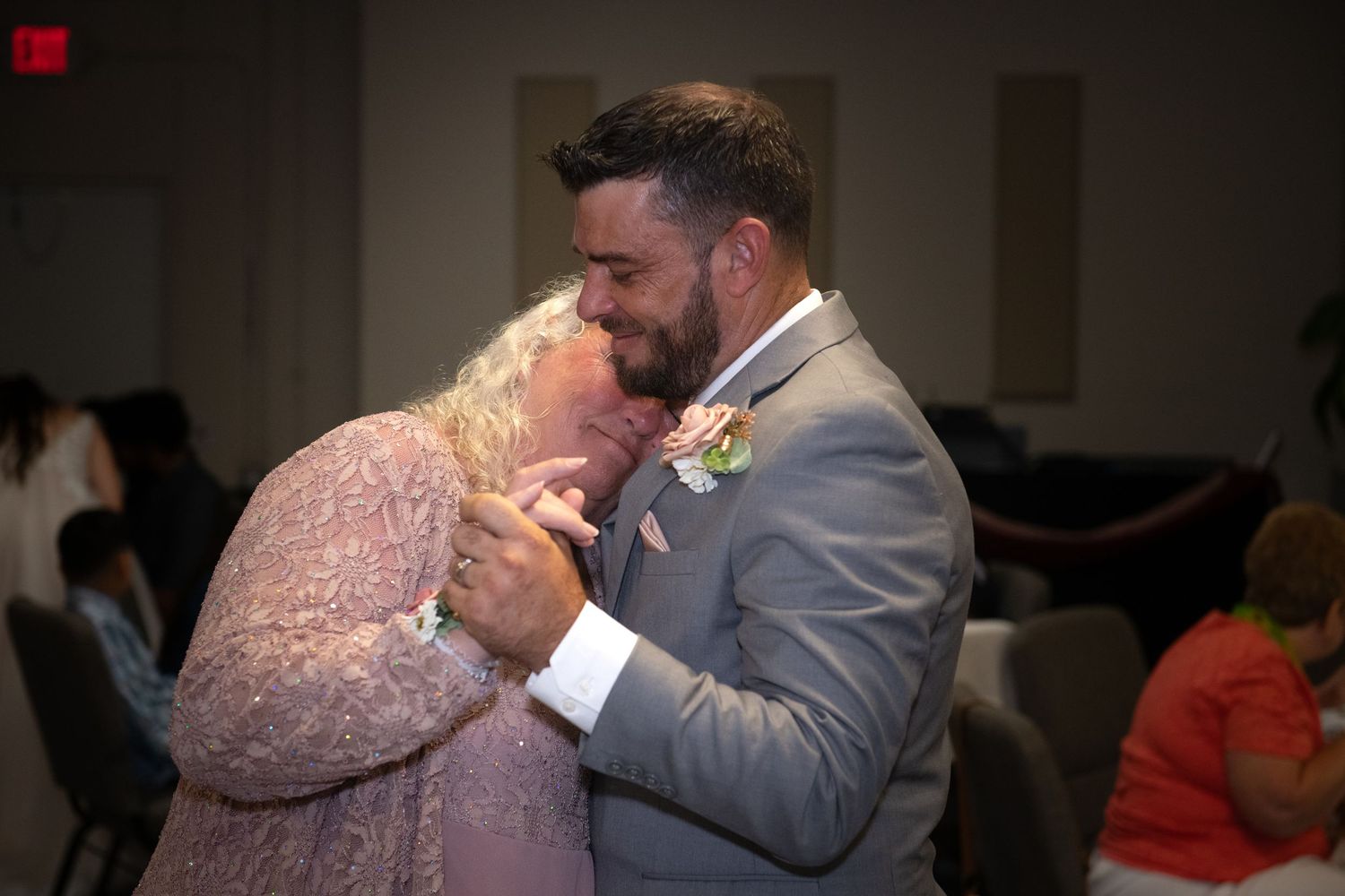 A tender embrace between newlyweds in a dimly lit setting.