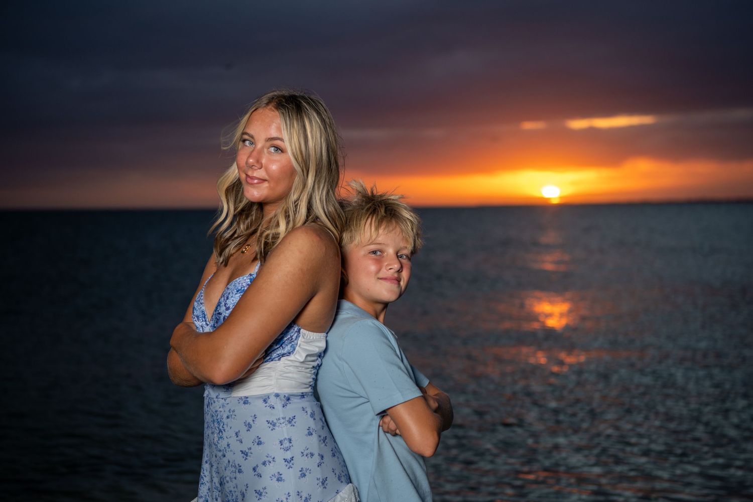 Dramatic sunset over ocean with silhouettes against orange sky. Beach photoshoot. Family photoshoot,