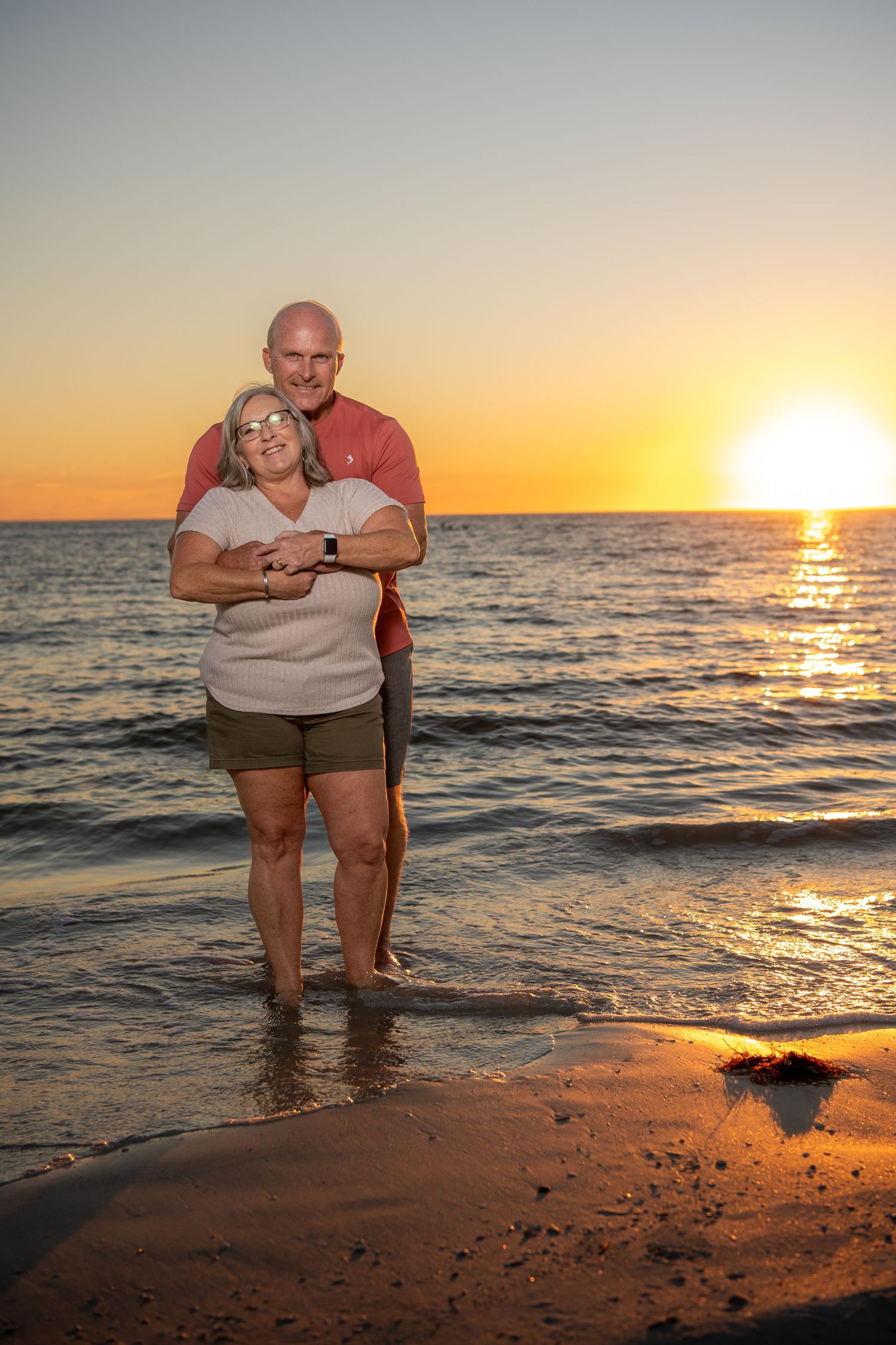 Romantic beach photoshoot at golden hour with waves crashing on the shore. Couples photoshoot.
