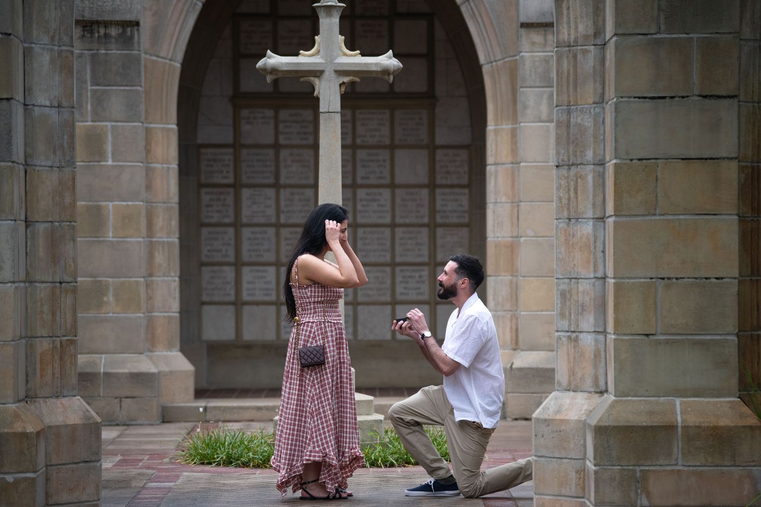 A proposal moment captured in a stone archway courtyard with gothic architecture details.