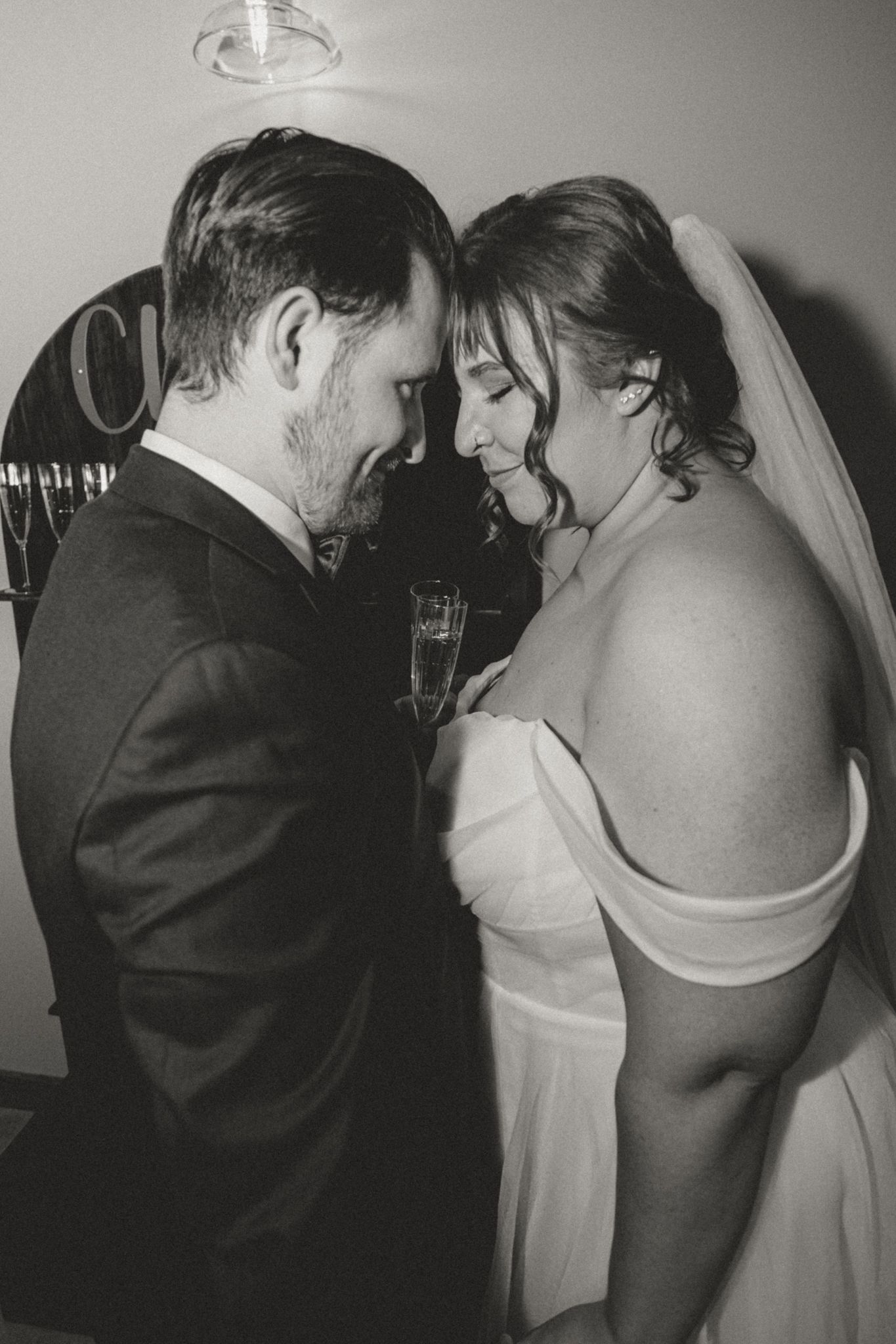 A romantic black and white photo series showing a couple in wedding attire sharing intimate moments during their special day.