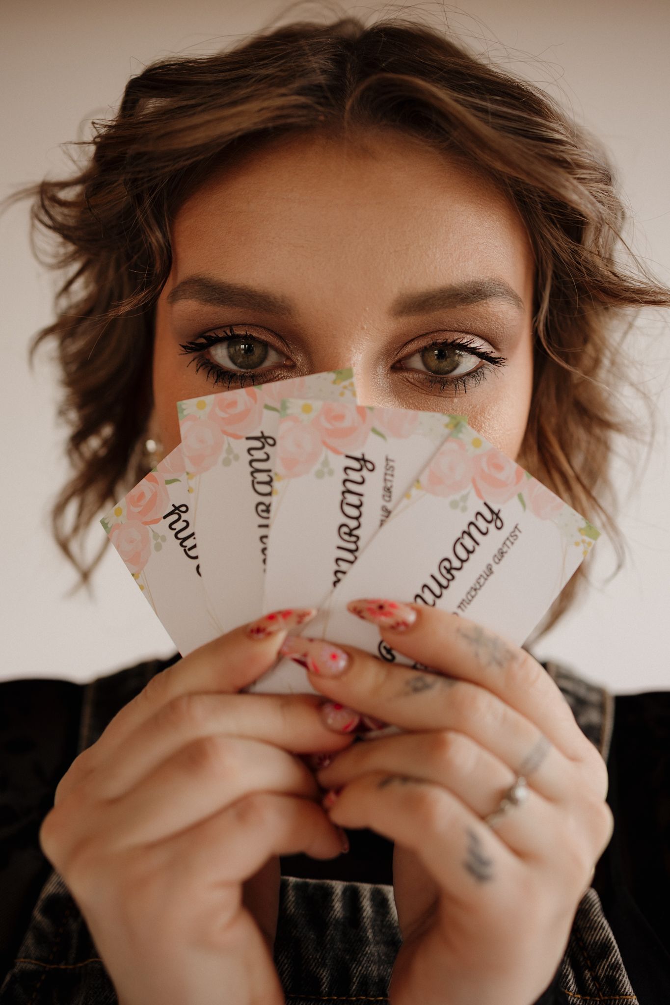 A series of five progressive photos showing hands holding torn paper pieces in front of the subject's face.
