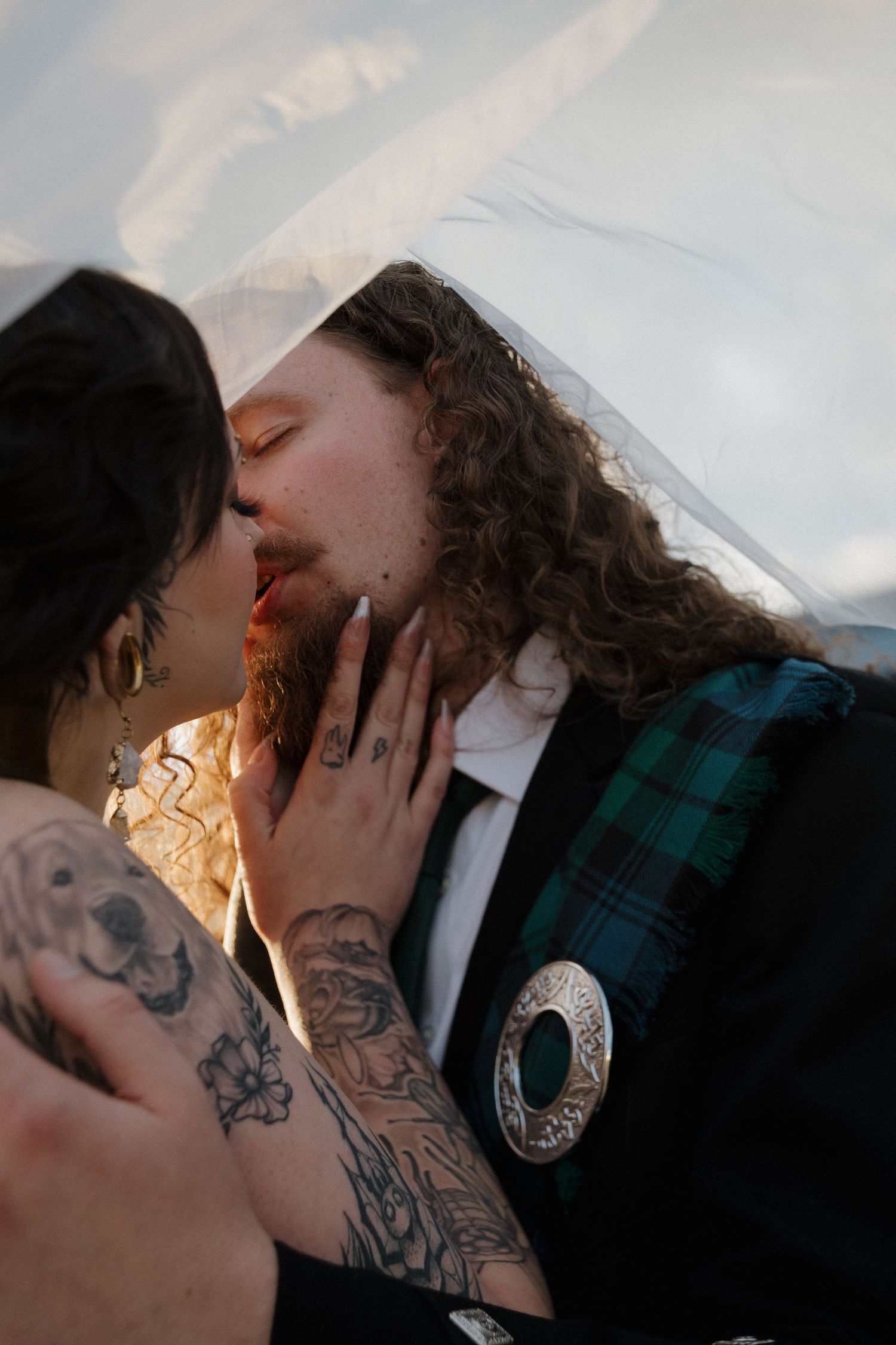 Romantic couple with visible tattoos sharing intimate kisses in a series of close-up shots.