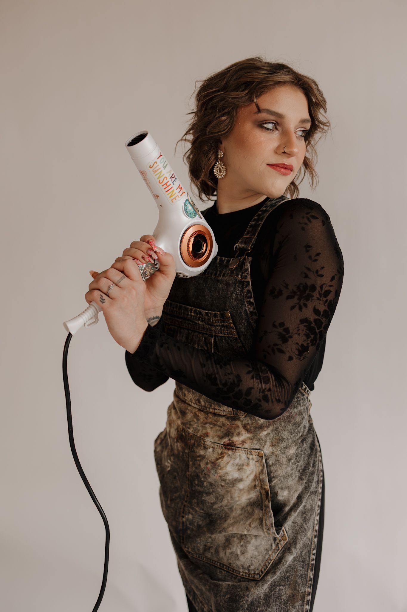 A person in a black lace top and velvet dress poses with a vintage telephone handset in a series of artistic shots.