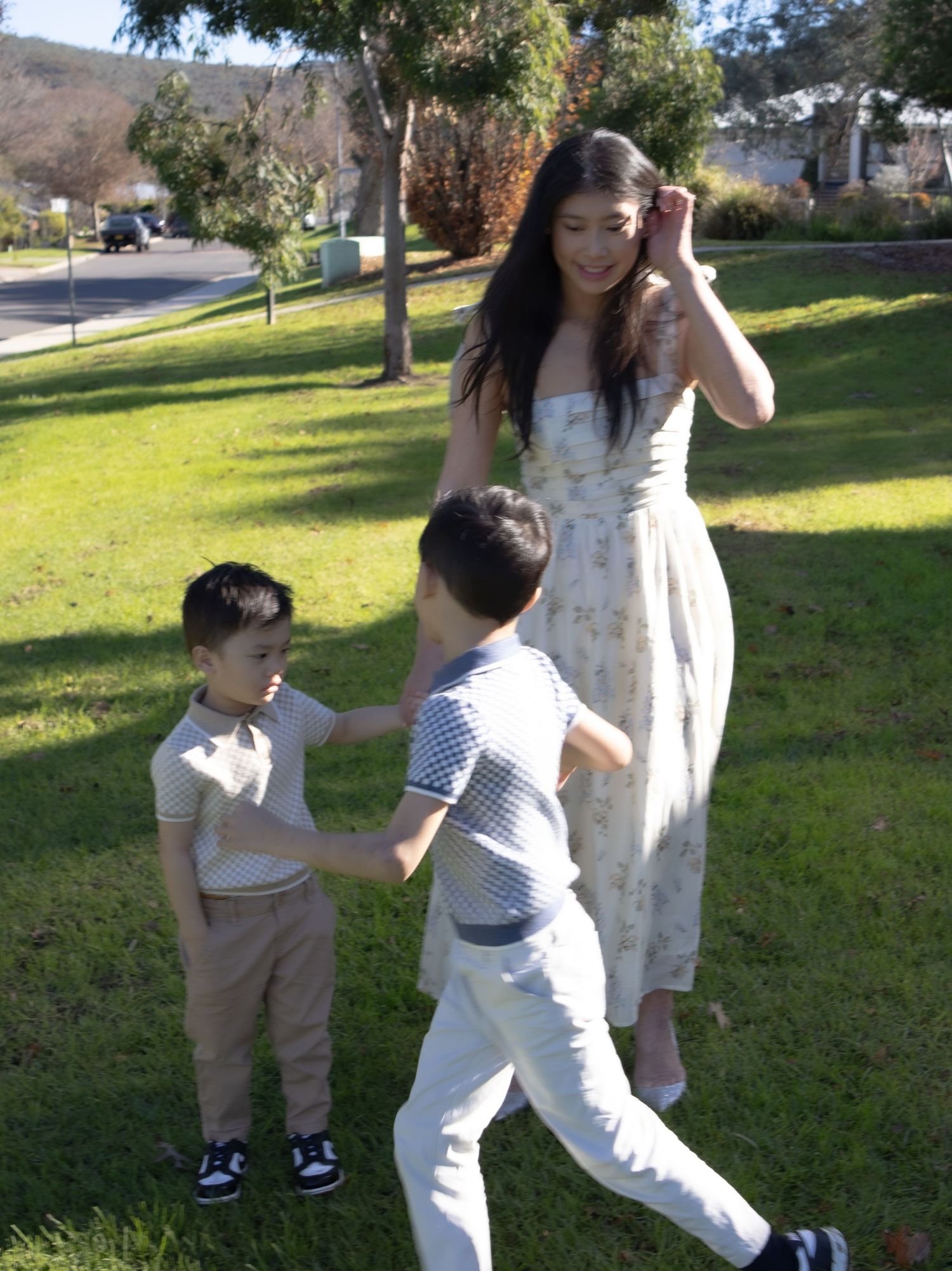 Two young boys running and playing around mum during an outdoor family photography session in Albury.