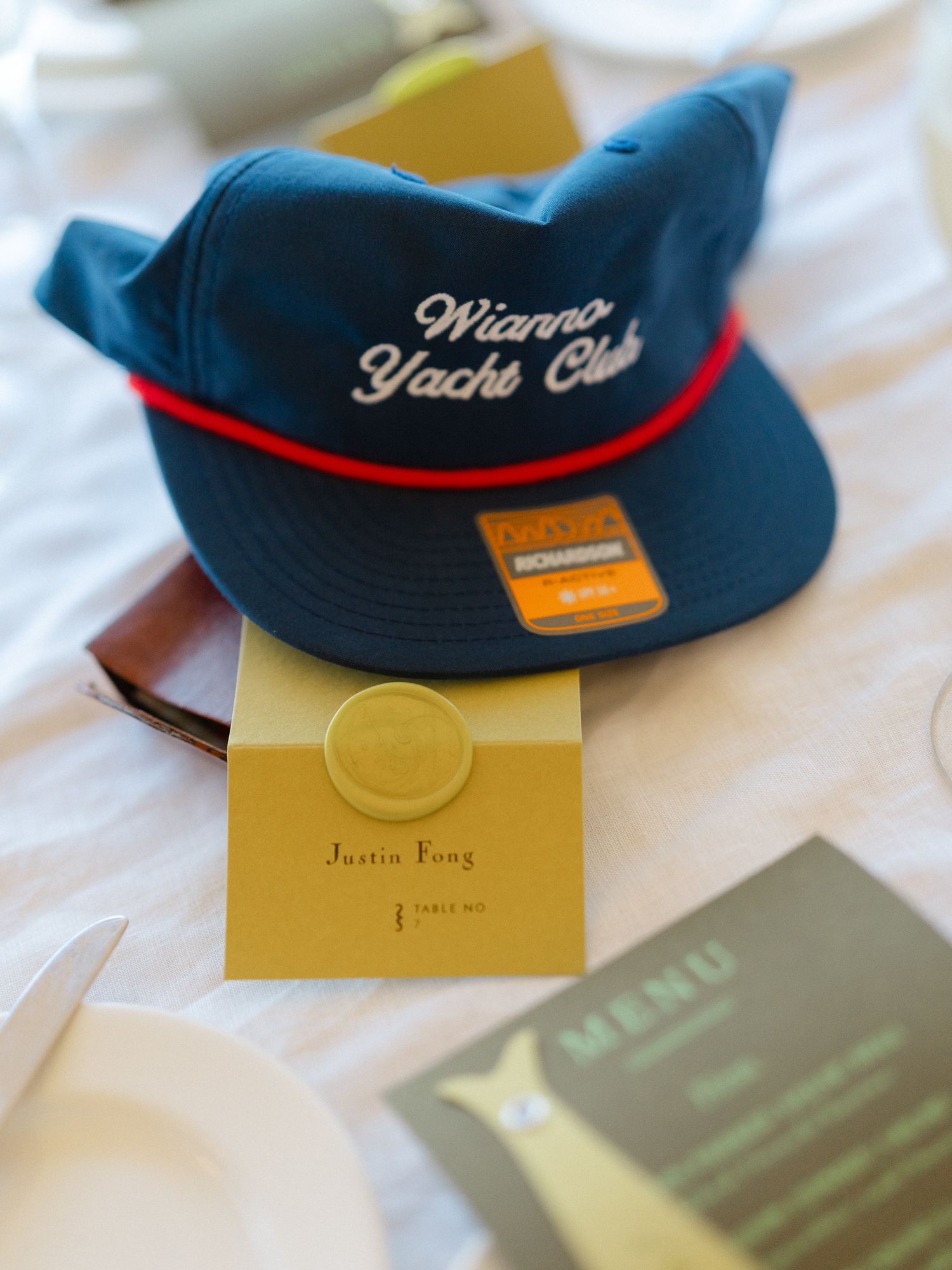 Wianna Yacht Club hat place setting with gold wax seal escort card at wedding.