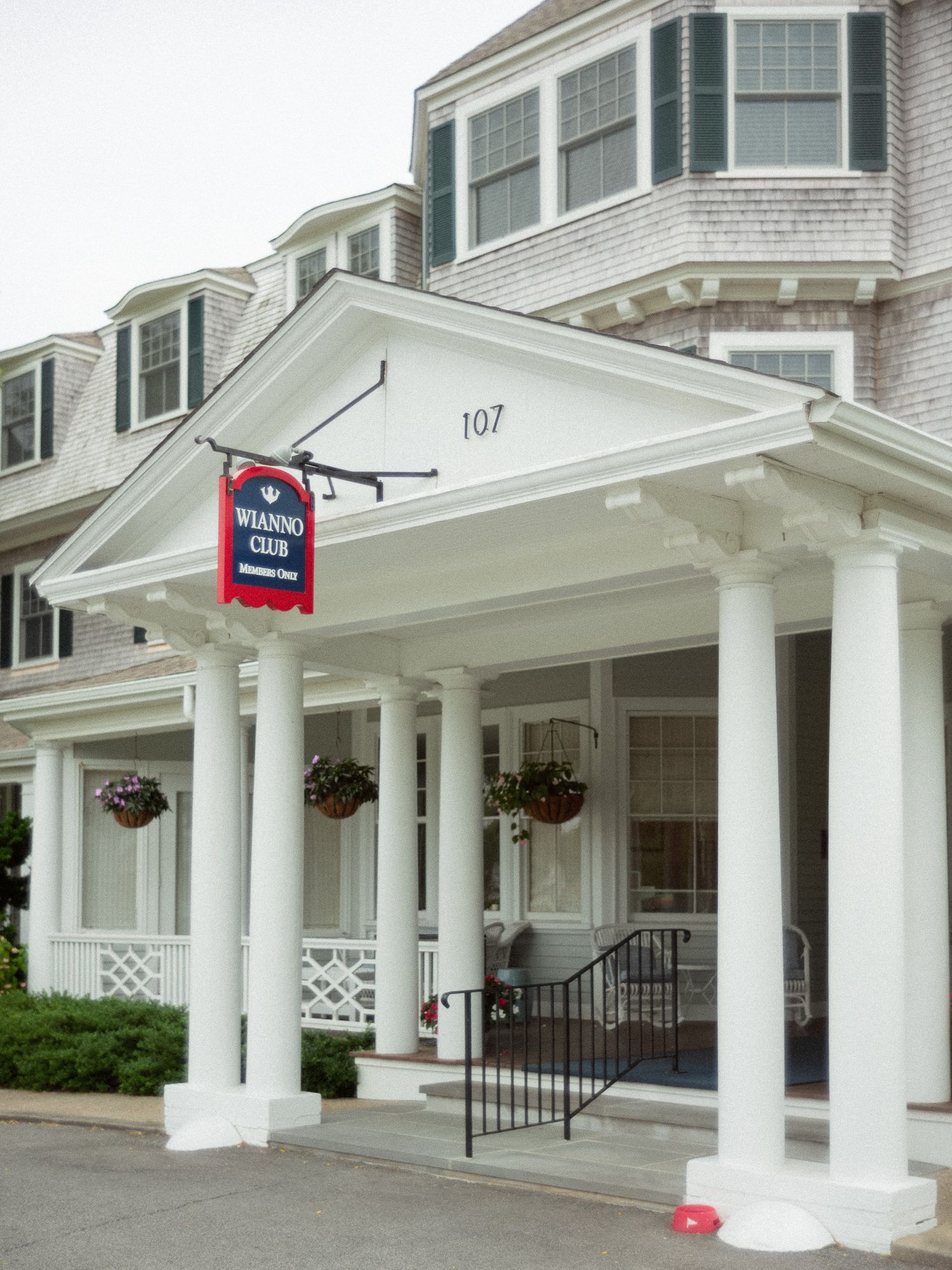 Classic New England shingled building exterior of the Wianno Club at 107 with white columns and portico.