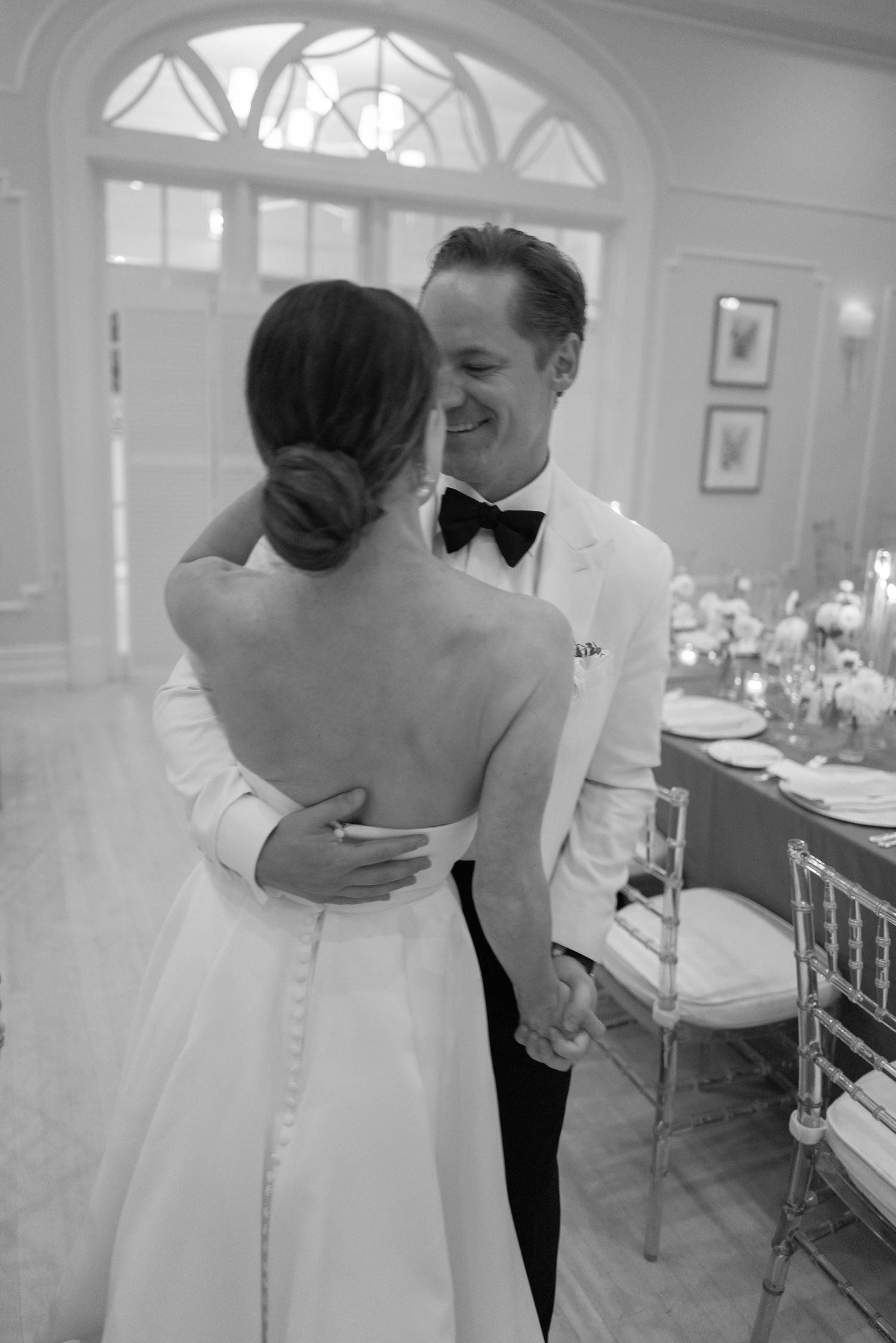 Black and white photo of bride and groom sharing intimate first dance moment at wedding reception.