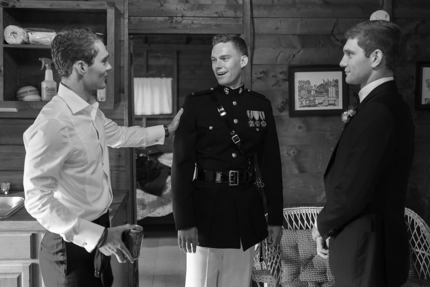 Black and white photo of three men talking, one wearing a military dress uniform with medals.