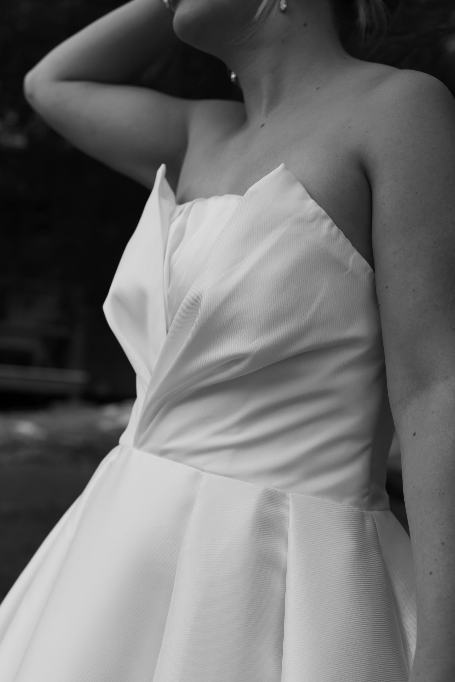 Black and white close-up of bride in strapless wedding gown.
