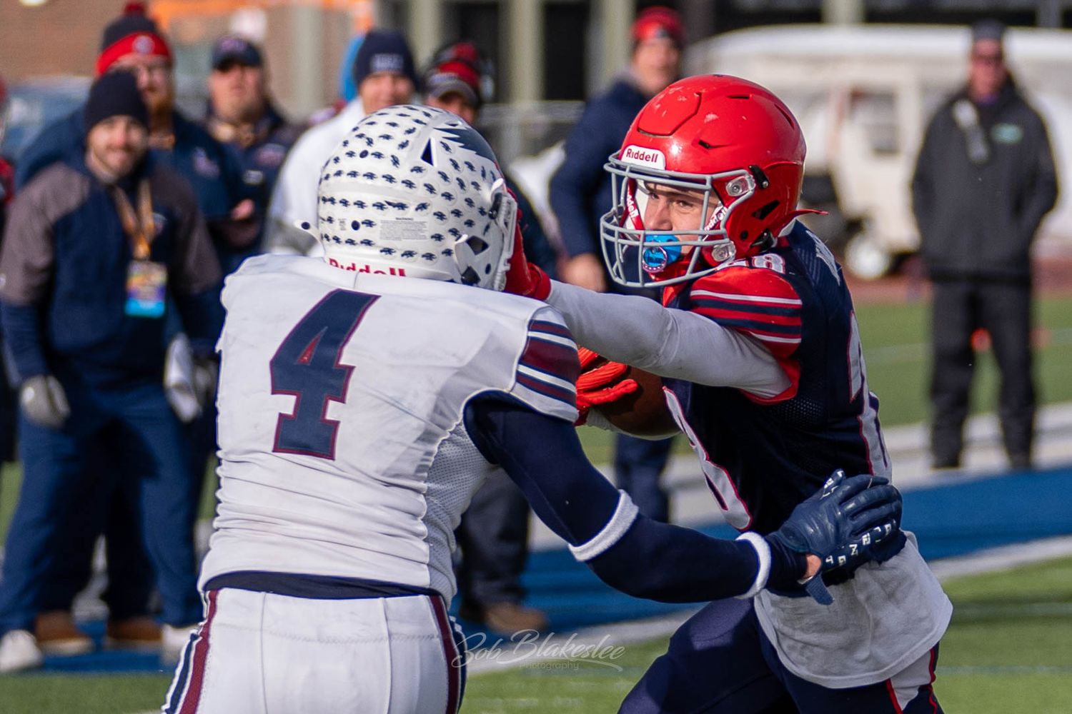 Varsity football player throws a stiff-arm at an attempted tackler during NYSPHSAA regional game in Cicero, NY