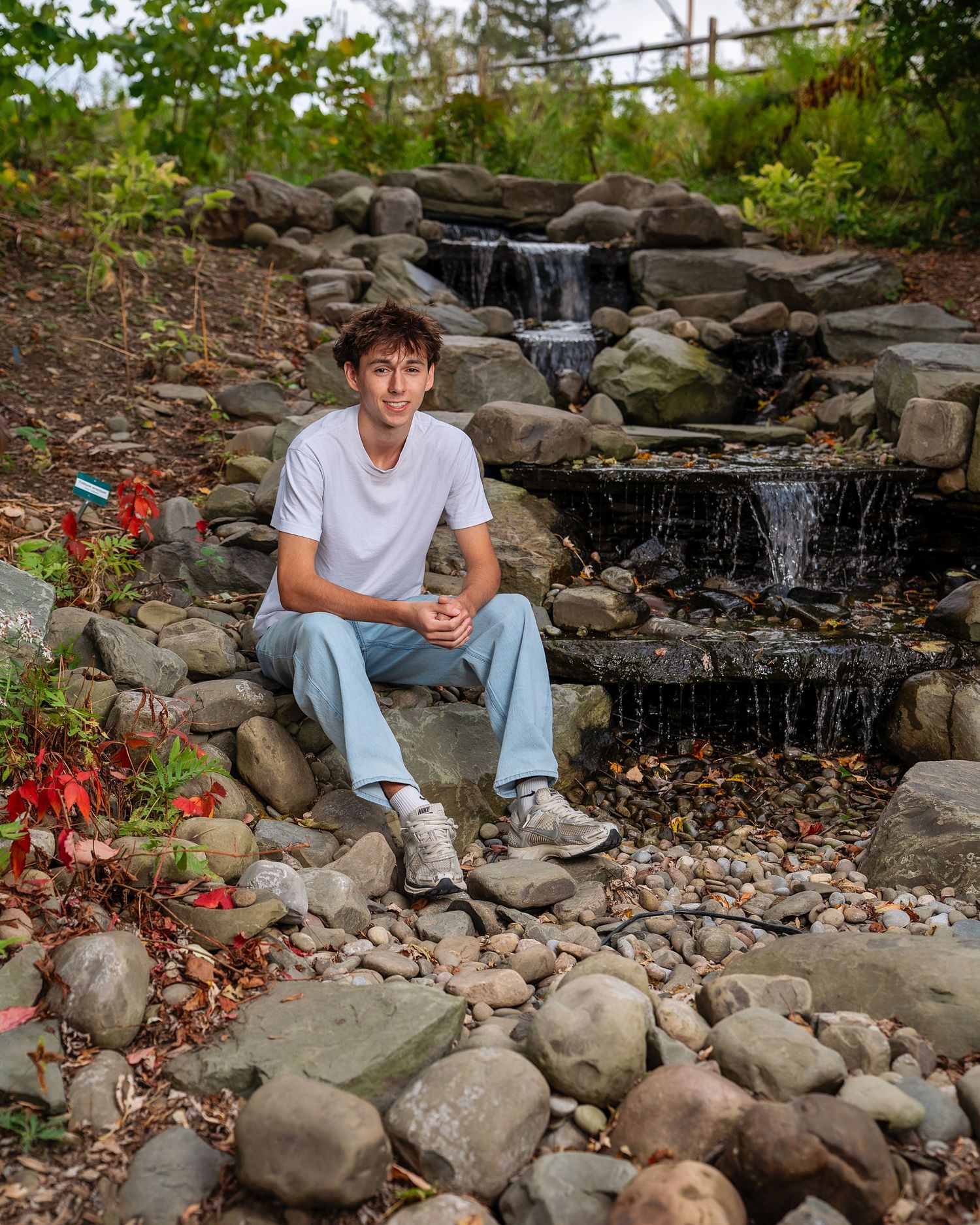 senior photo boy sitting beside a waterfall in dickinson ny