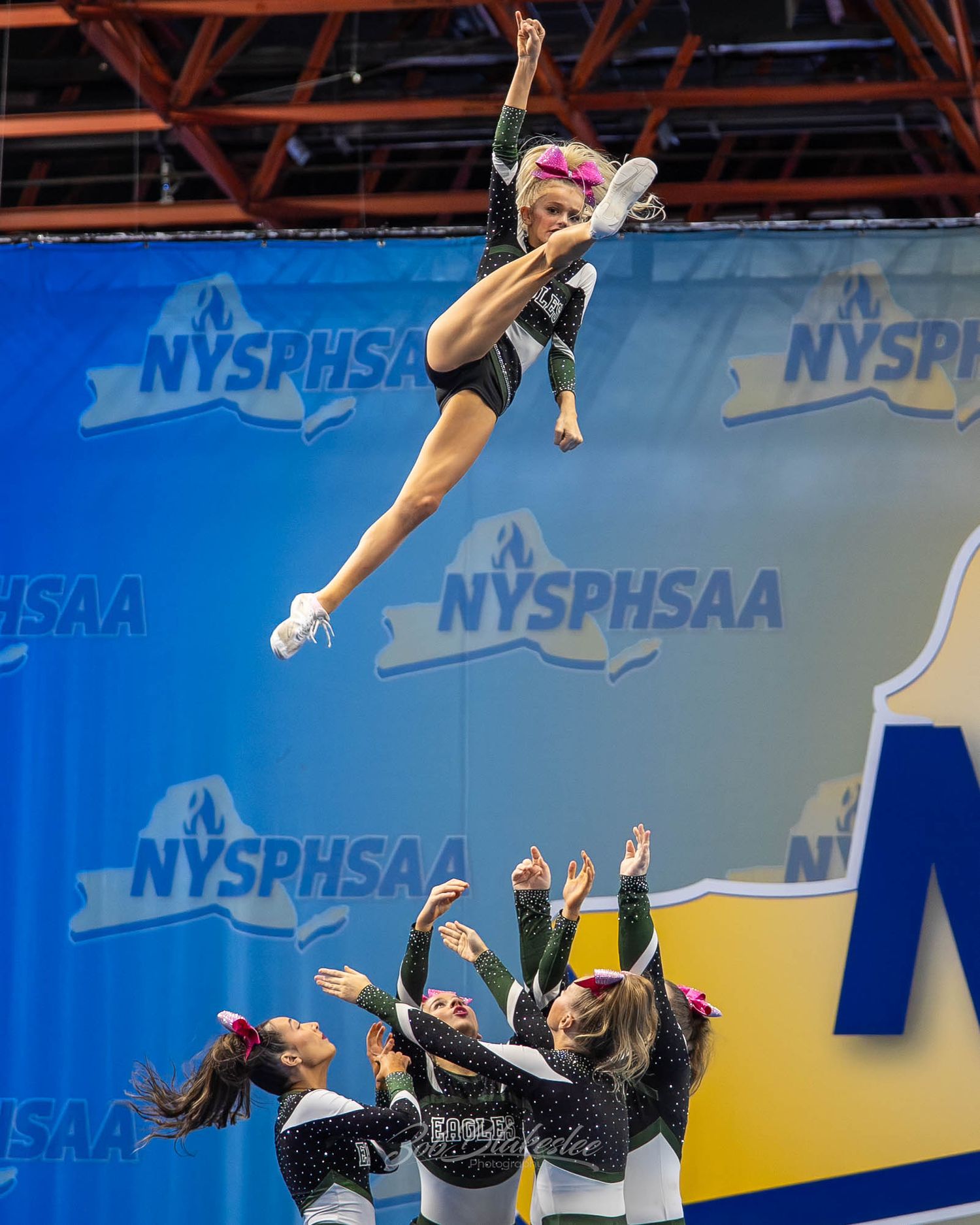 Cheerleader is tossed high in the air by teammates at the NYSPHSAA Championships competition.