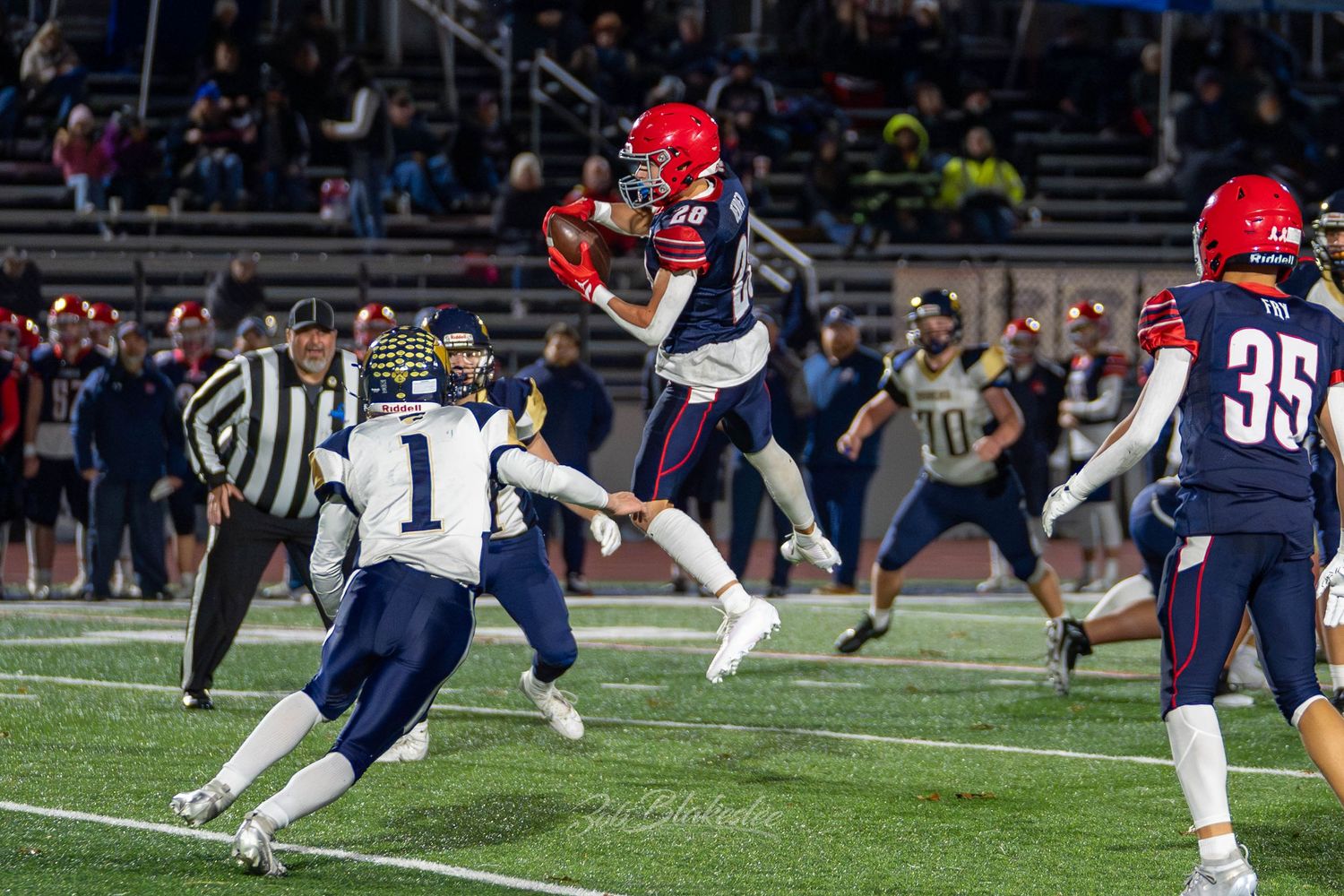 High school football player hurdles a defender during a varsity Section IV football game.