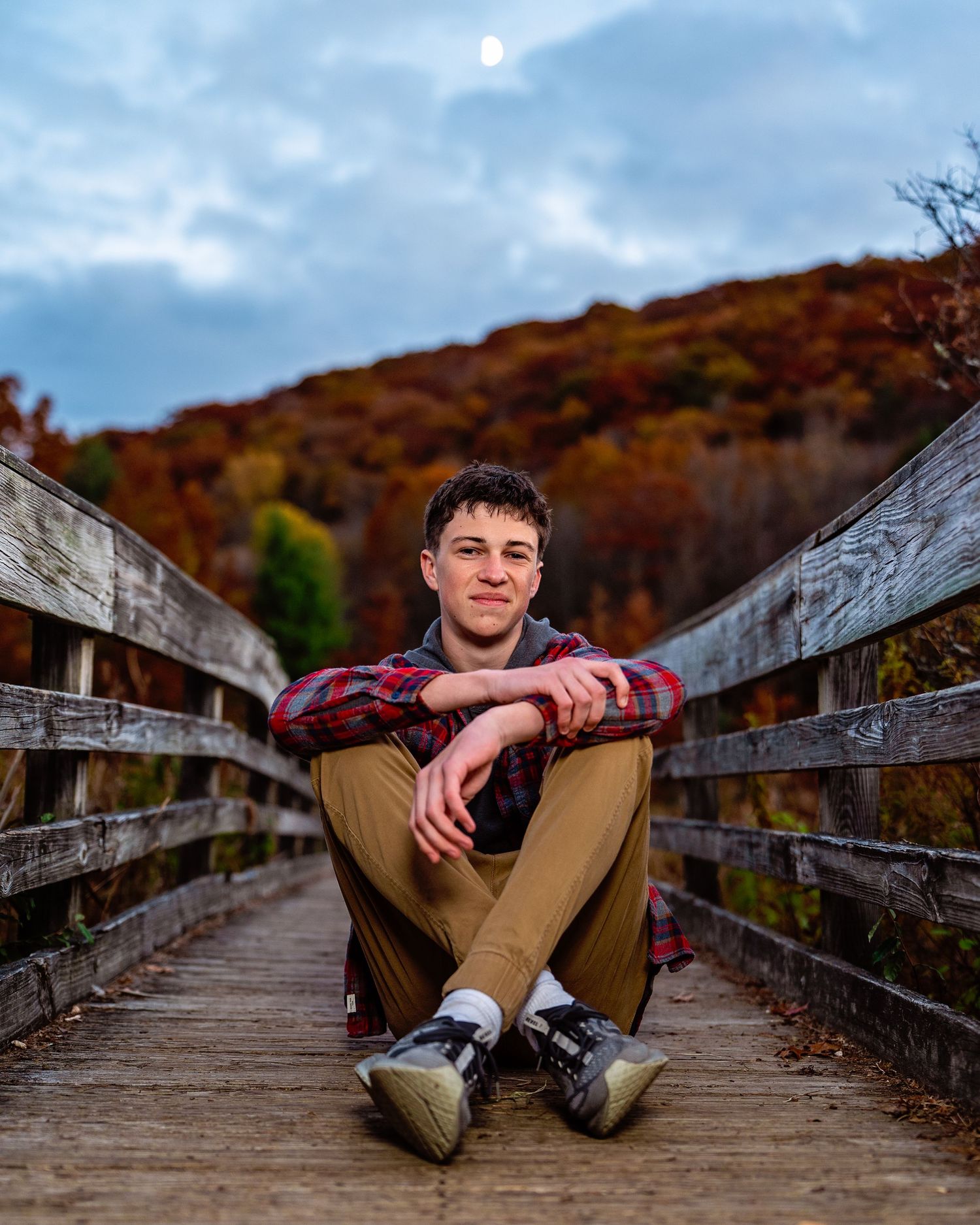 Outdoor senior portrait of a high school athlete photographed on a bridge during a fall senior session in Vestal, NY.