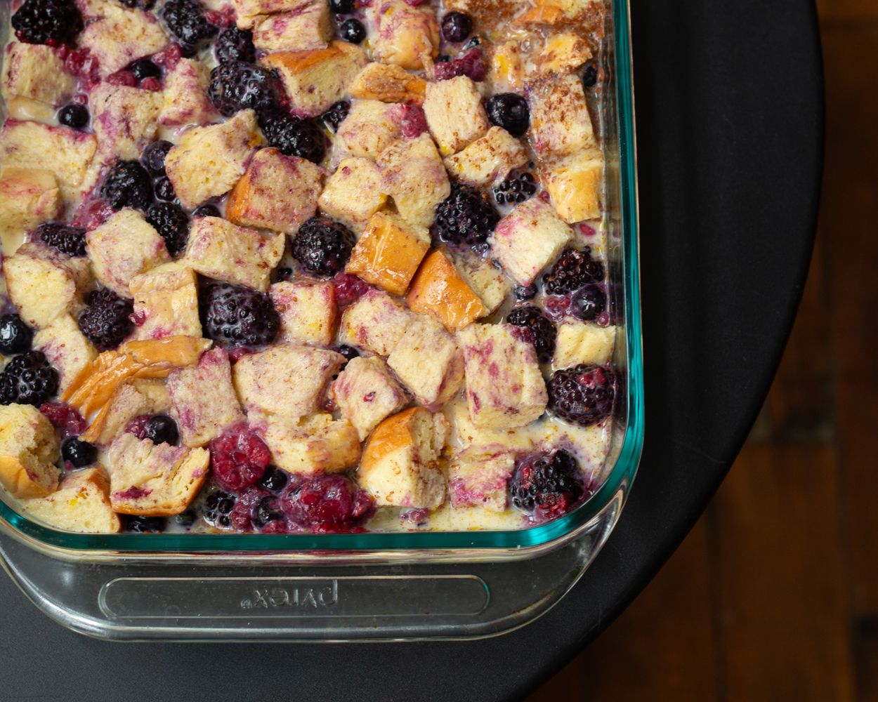 Blueberry and peach bread pudding baked in a glass casserole dish.