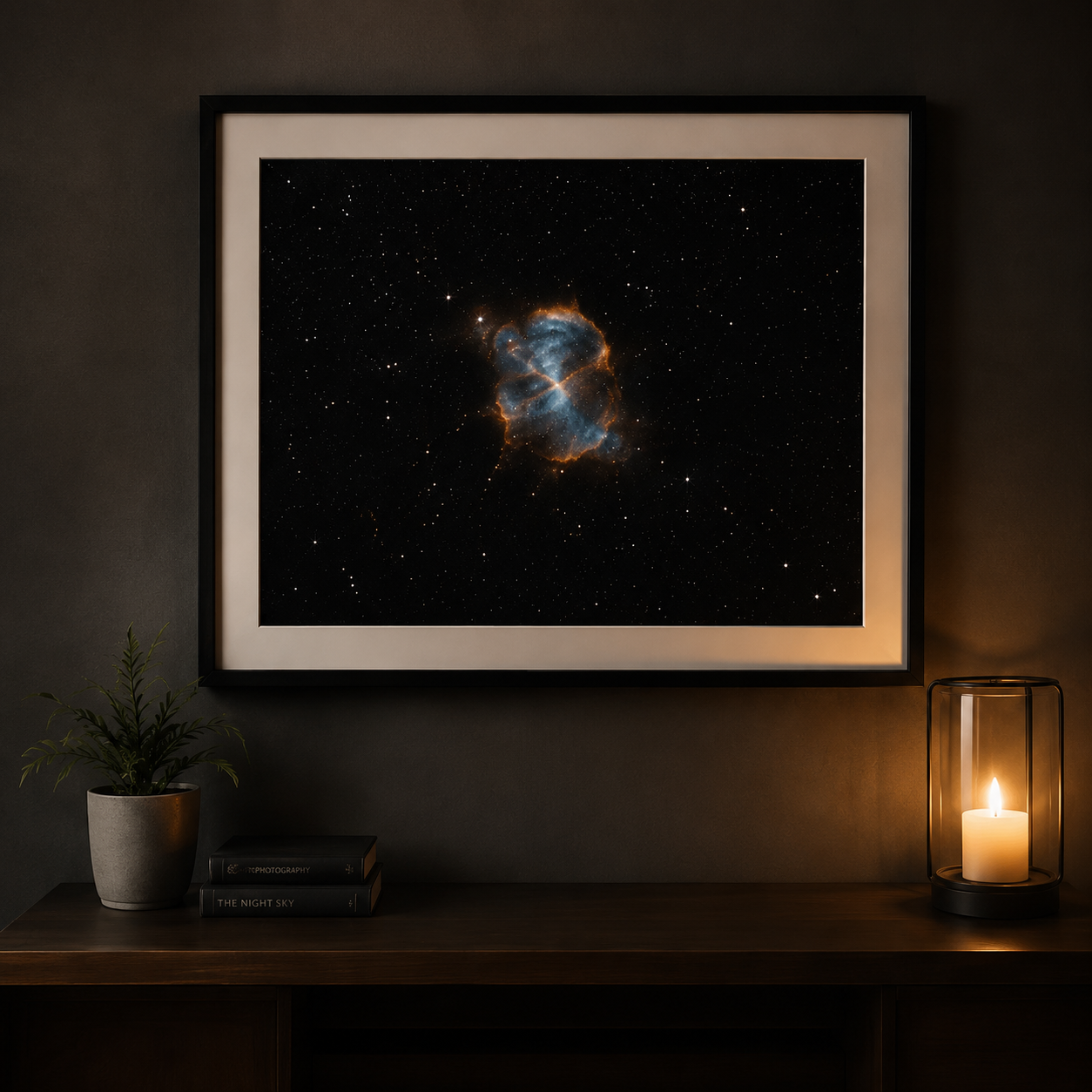 Framed nebula space art print hanging on dark wall above wooden console table with candle and plant.