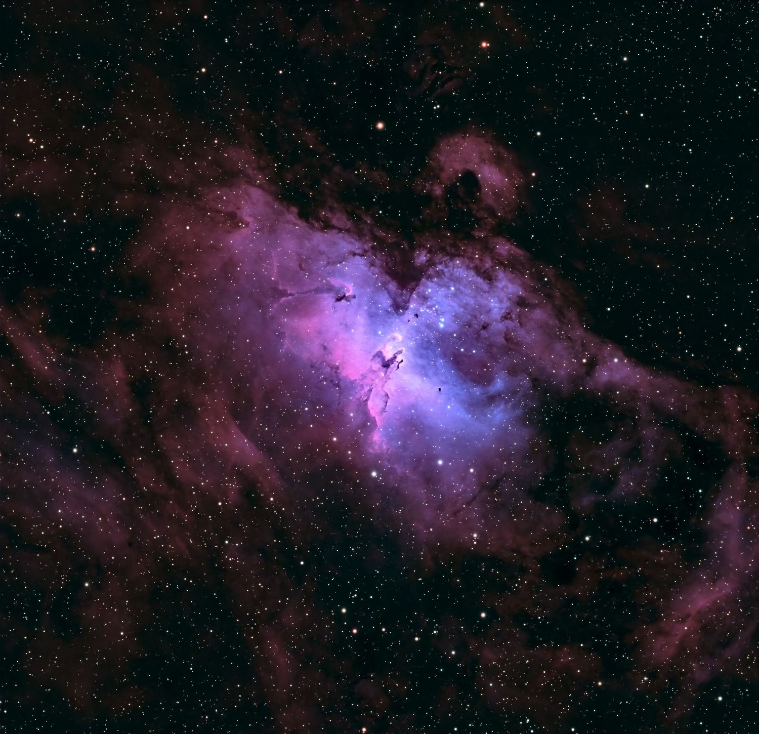 The Eagle Nebula M16 captured in stunning purple and blue hues, showcasing star-forming pillars in deep space.