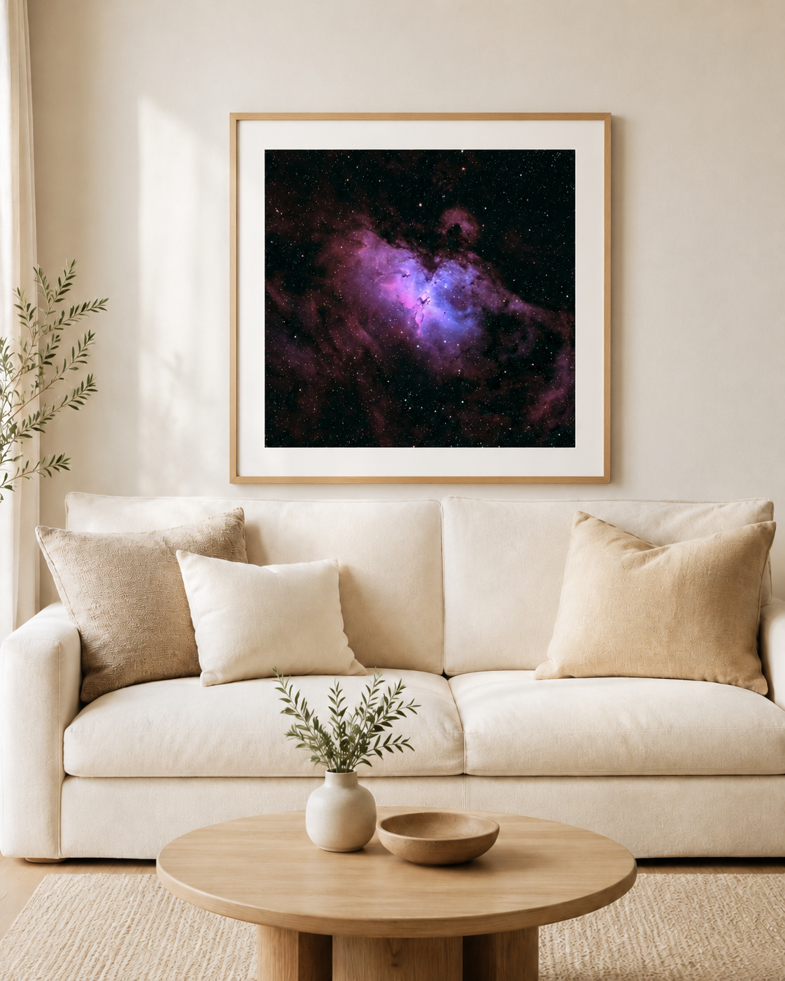 Framed purple and blue nebula space art print hanging above a white linen sofa in a neutral modern living room.