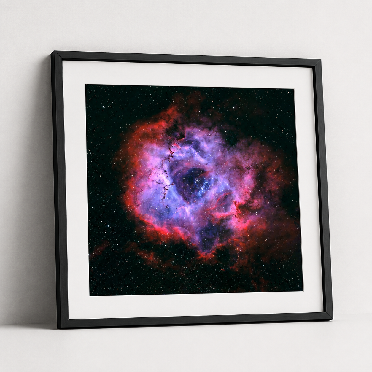 Framed print of the Rosette Nebula featuring vivid red and purple cosmic clouds against a star-filled black background.