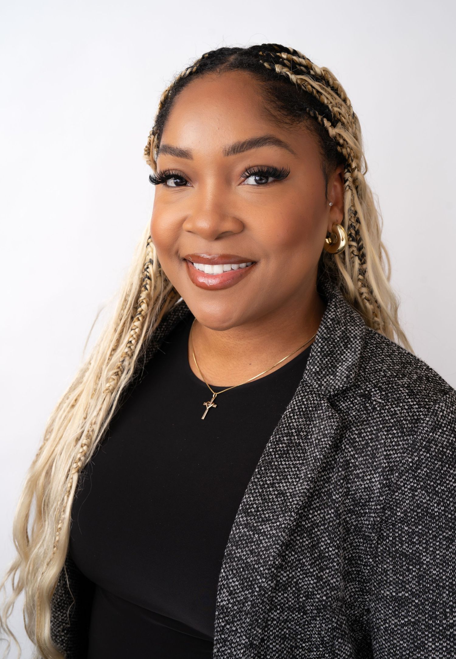 Stylish portrait series showing person in black outfit with blonde braids against white backdrop.