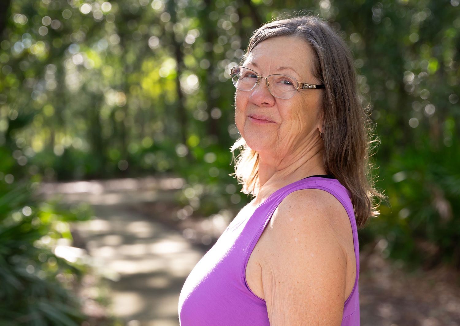 Outdoor portraits in a wooded setting with someone wearing a purple top.
