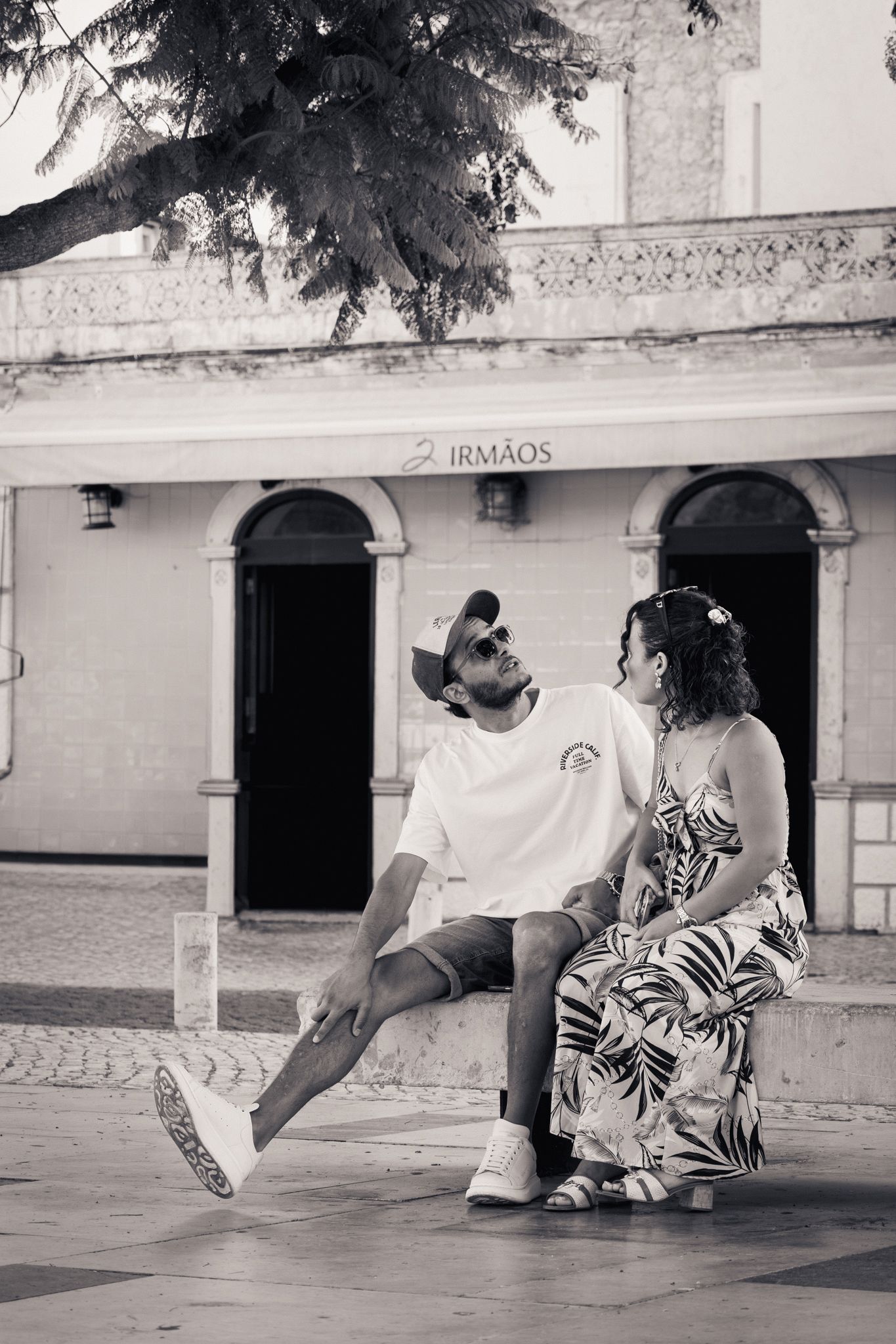 Photo en noir et blanc d'un couple assis ensemble sur un banc