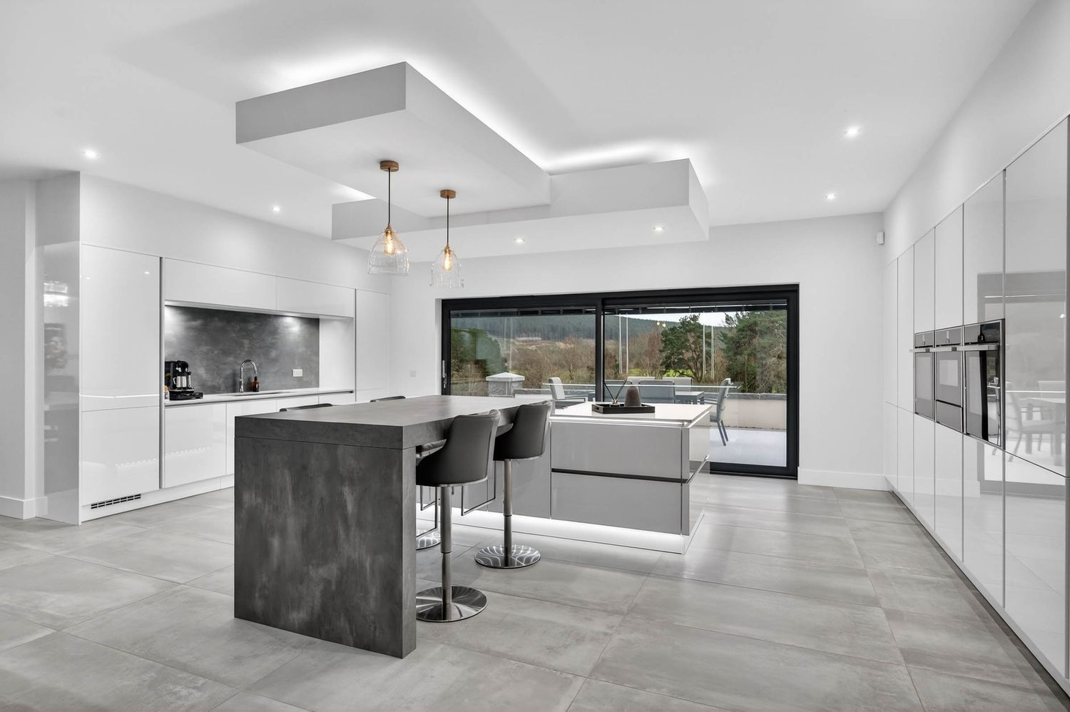 Spacious white contemporary living area with minimalist design featuring black accents and large windows.
