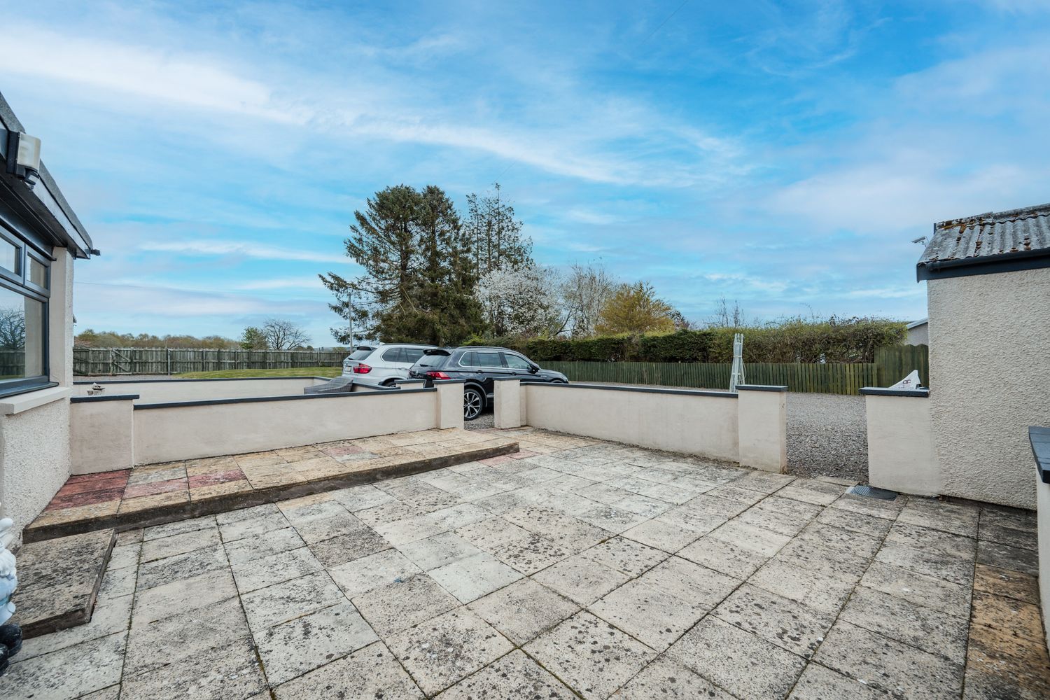 Spacious rooftop terrace with concrete tile flooring and panoramic countryside views under blue skies.
