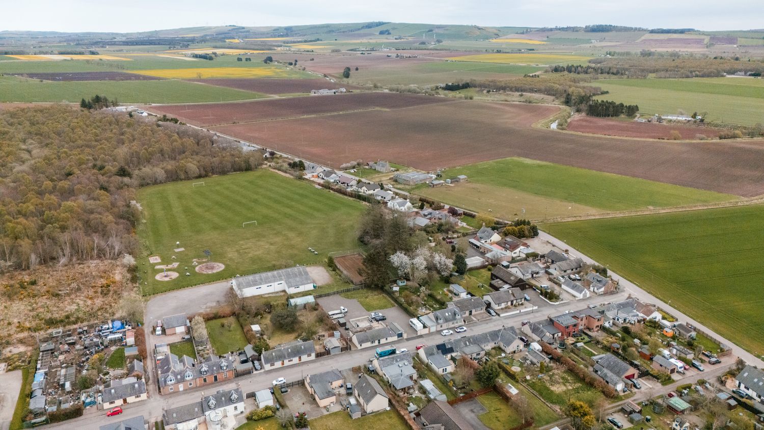 Aerial view of a small rural town surrounded by farmland and agricultural fields.