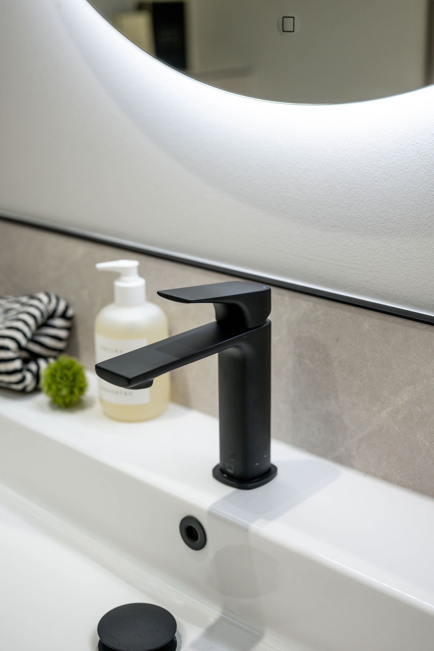 Modern black bathroom faucet shown in detail against white surface.