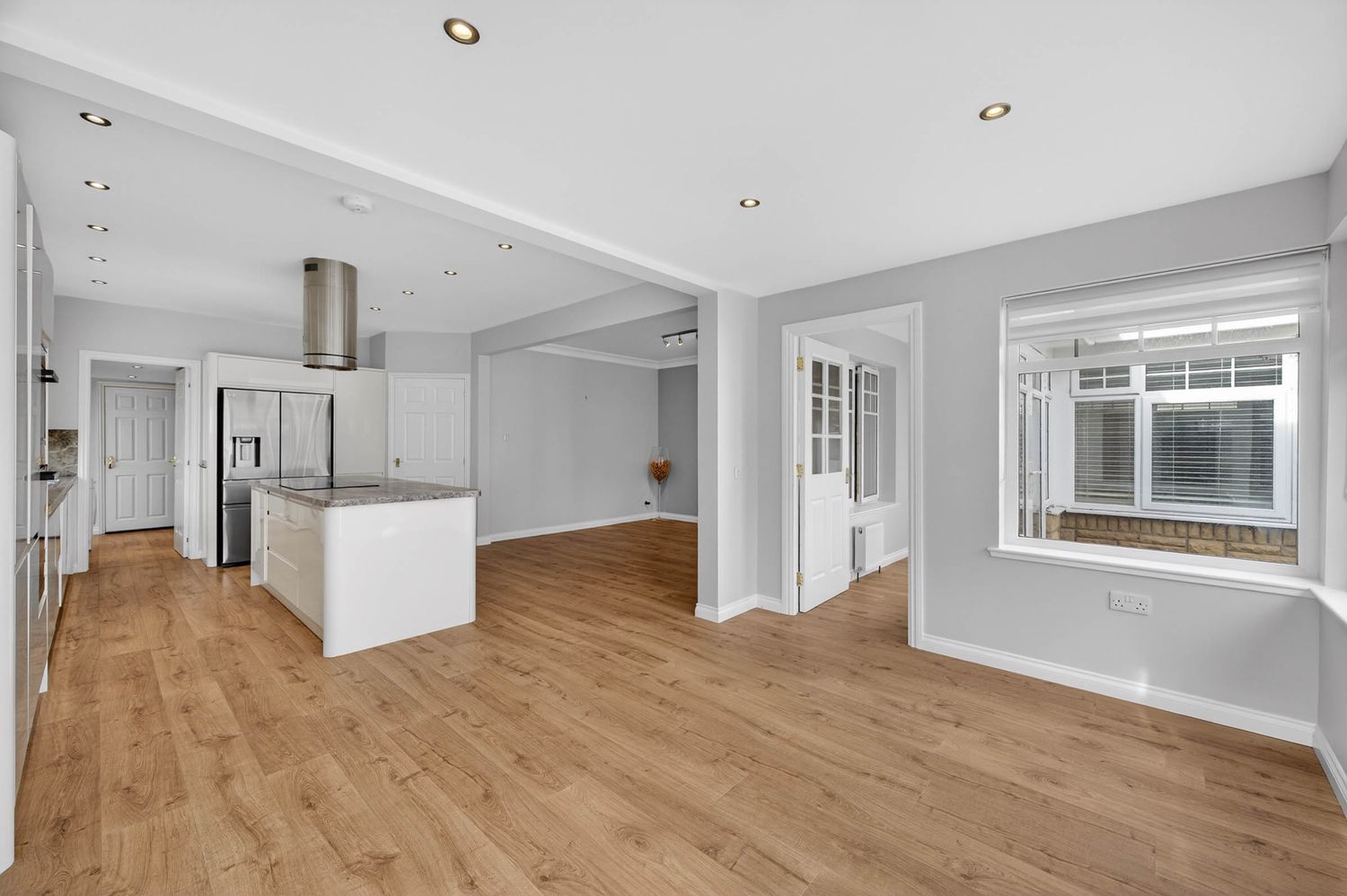 Modern open concept living space with hardwood floors and white walls showcasing a minimalist design aesthetic.