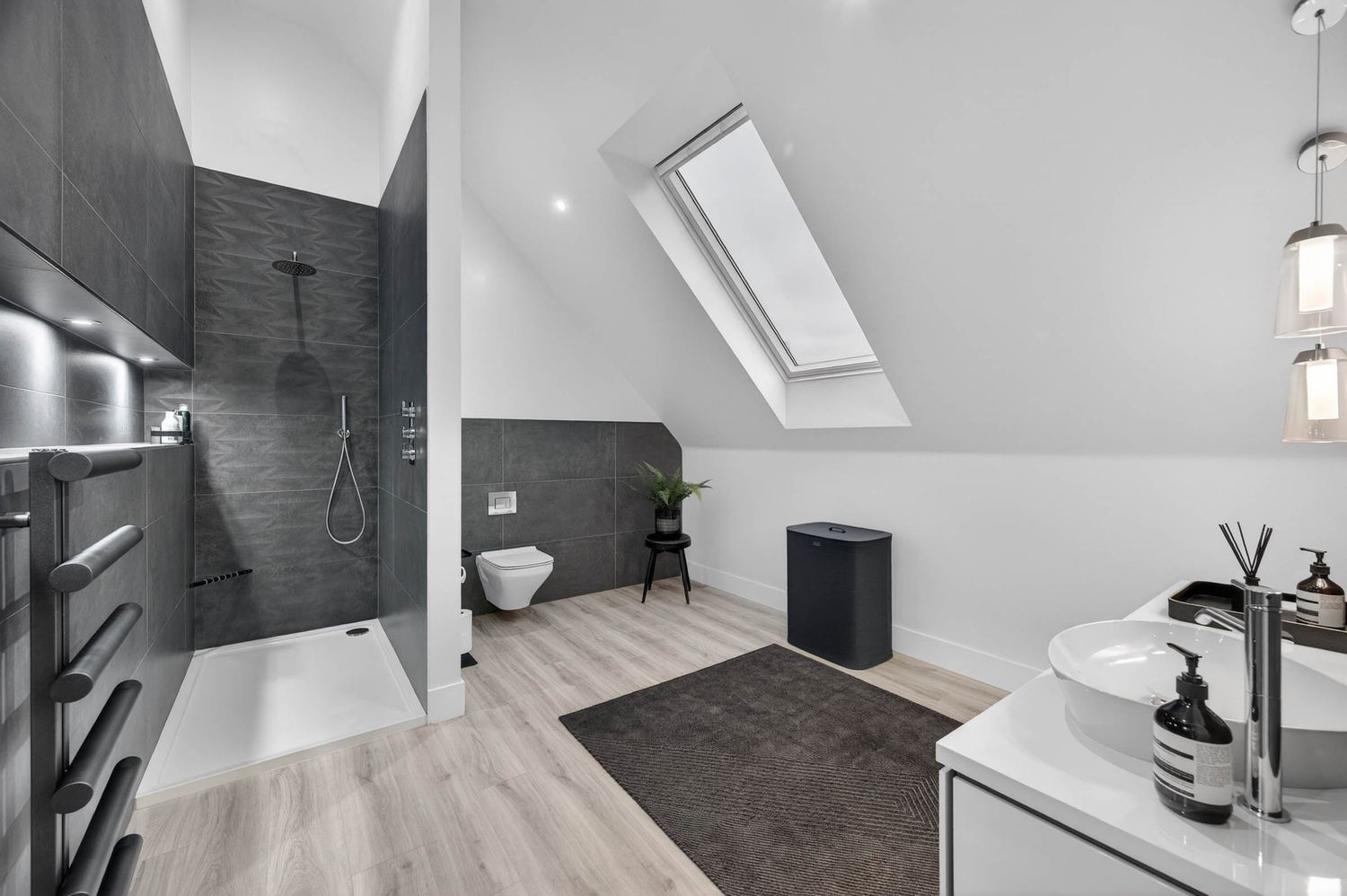 Minimalist loft workspace featuring clean white walls and contemporary lighting fixtures.