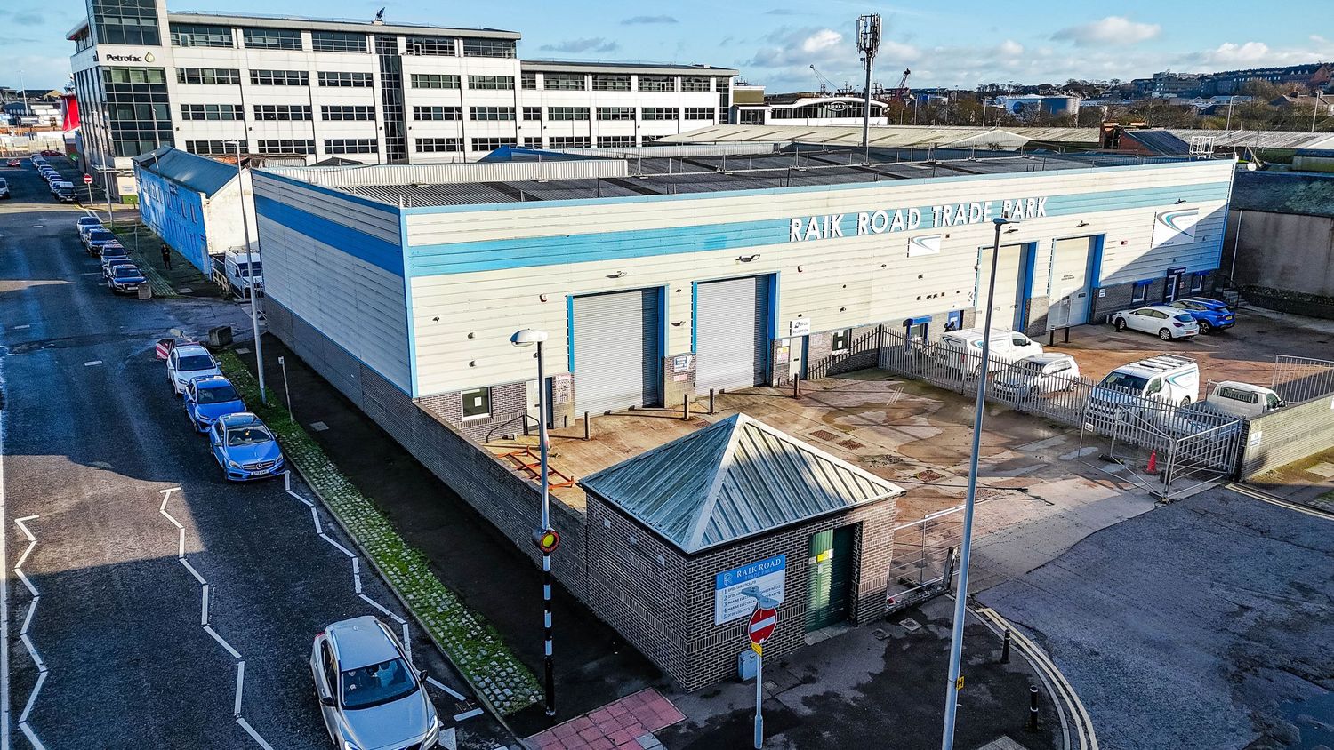 Wide aerial view of an industrial complex with warehouses and parking areas.