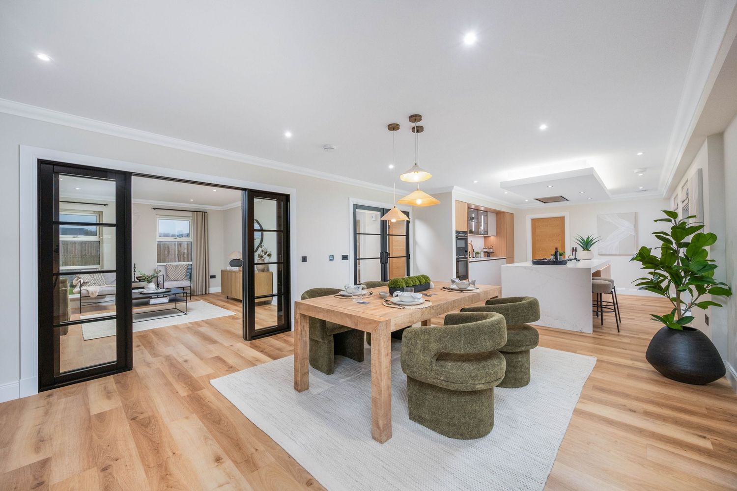 Open plan living space with light wood floors and modern furniture in neutral tones.