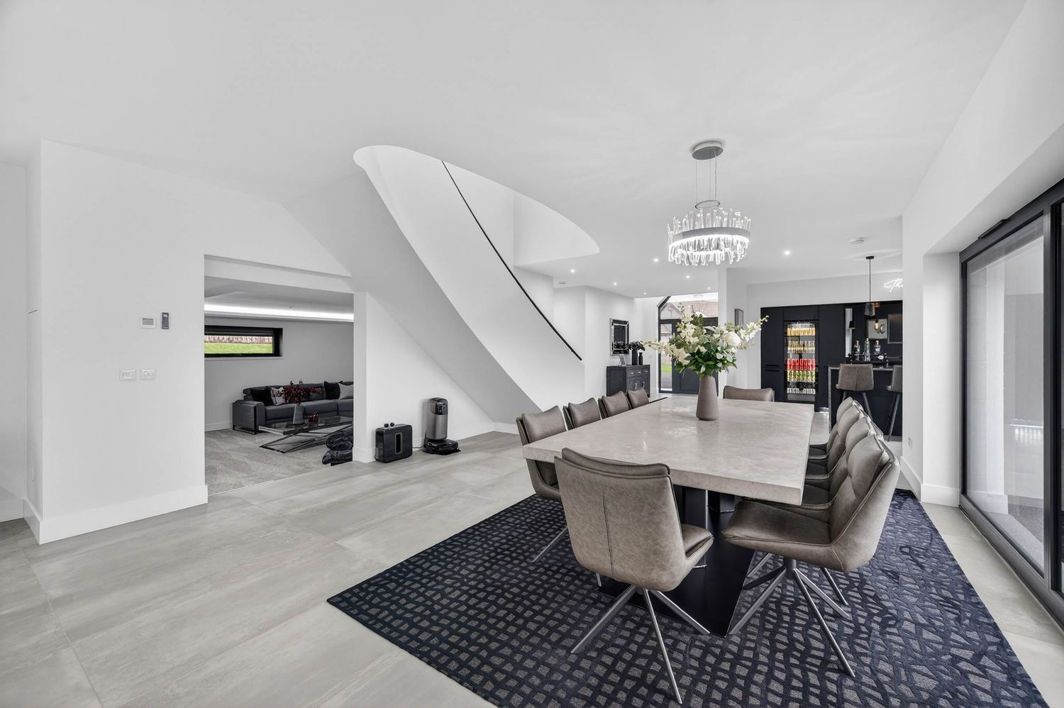 Modern minimalist hallway with black and white geometric carpet runner leading to white walls and stairs.