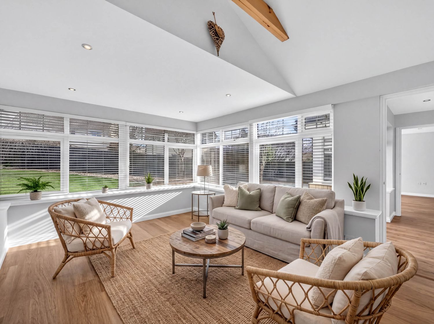 Luxurious open floor plan combining living and dining areas with large windows and modern furnishings.