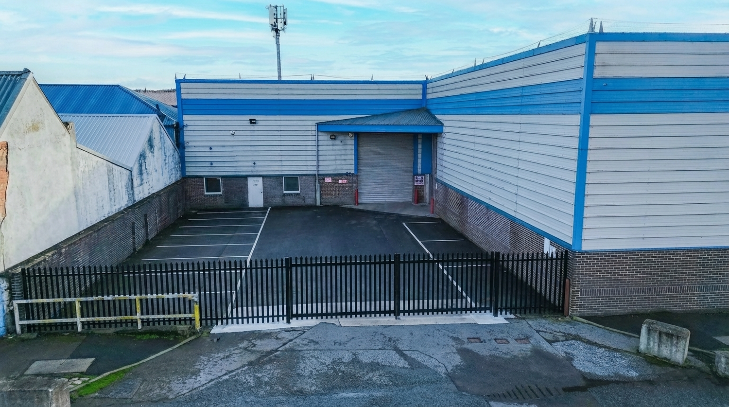 Panoramic shot of commercial warehouse exteriors with delivery bays and parking areas.
