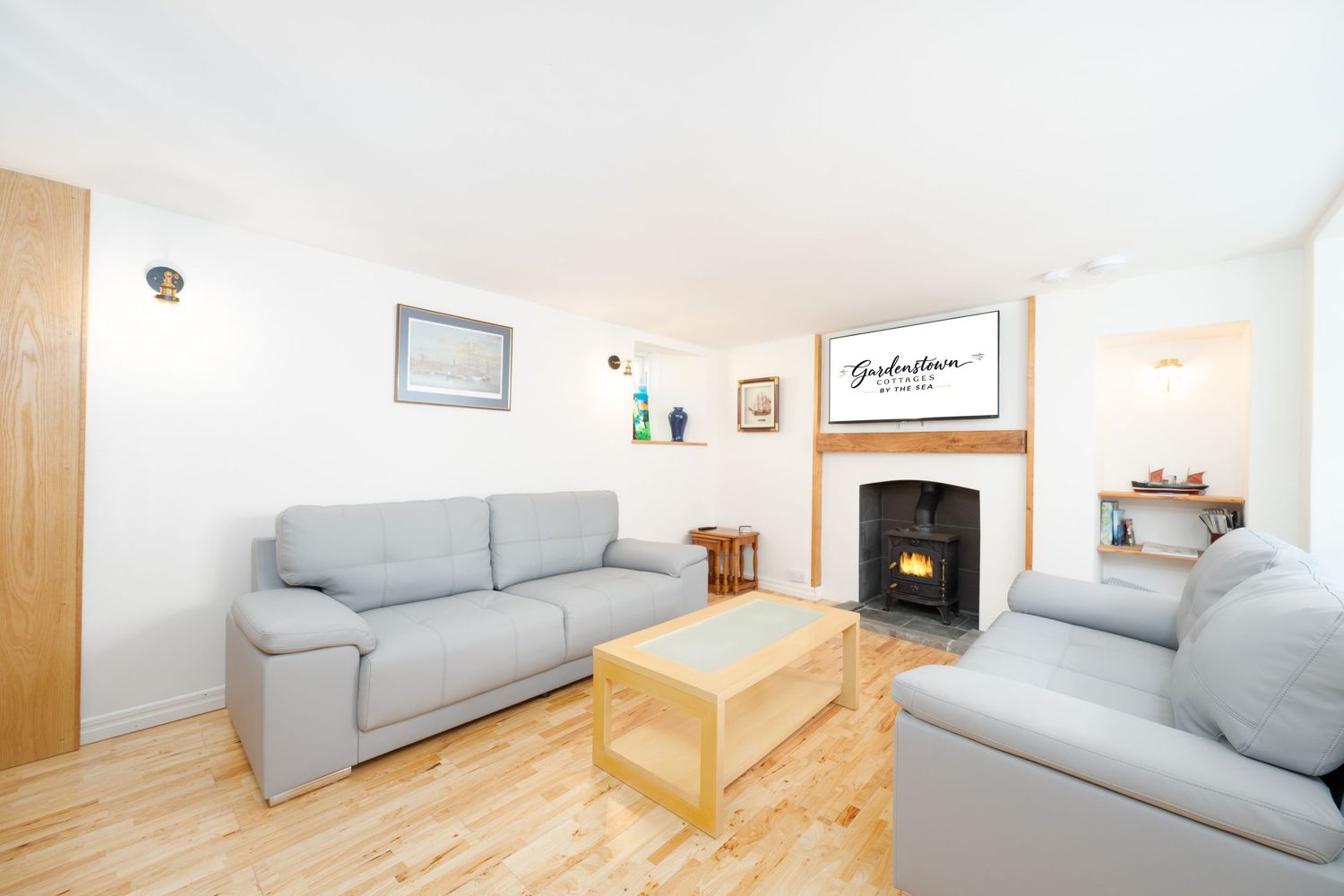 Cozy living room with light gray sofas, wooden coffee table and fireplace in a contemporary coastal home.