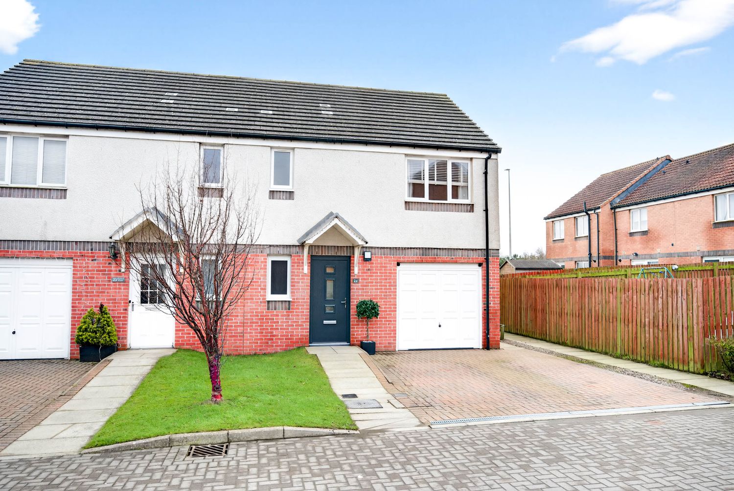 Semi-detached modern house with red brick base, white upper level, and integrated garage.