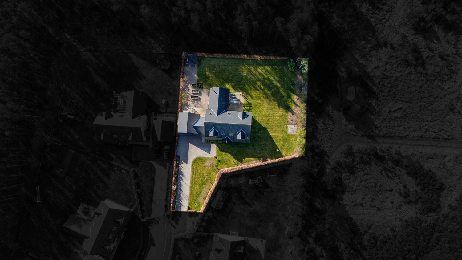 Aerial view of a rural property with buildings nestled among trees, captured from directly above.